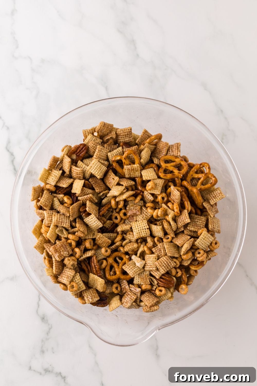 Pumpkin Spice Chex Mix in a glass bowl on table for preparing it