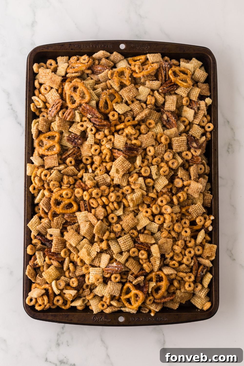 sheet pan full of Pumpkin Spice Chex Mix on a marble counter 