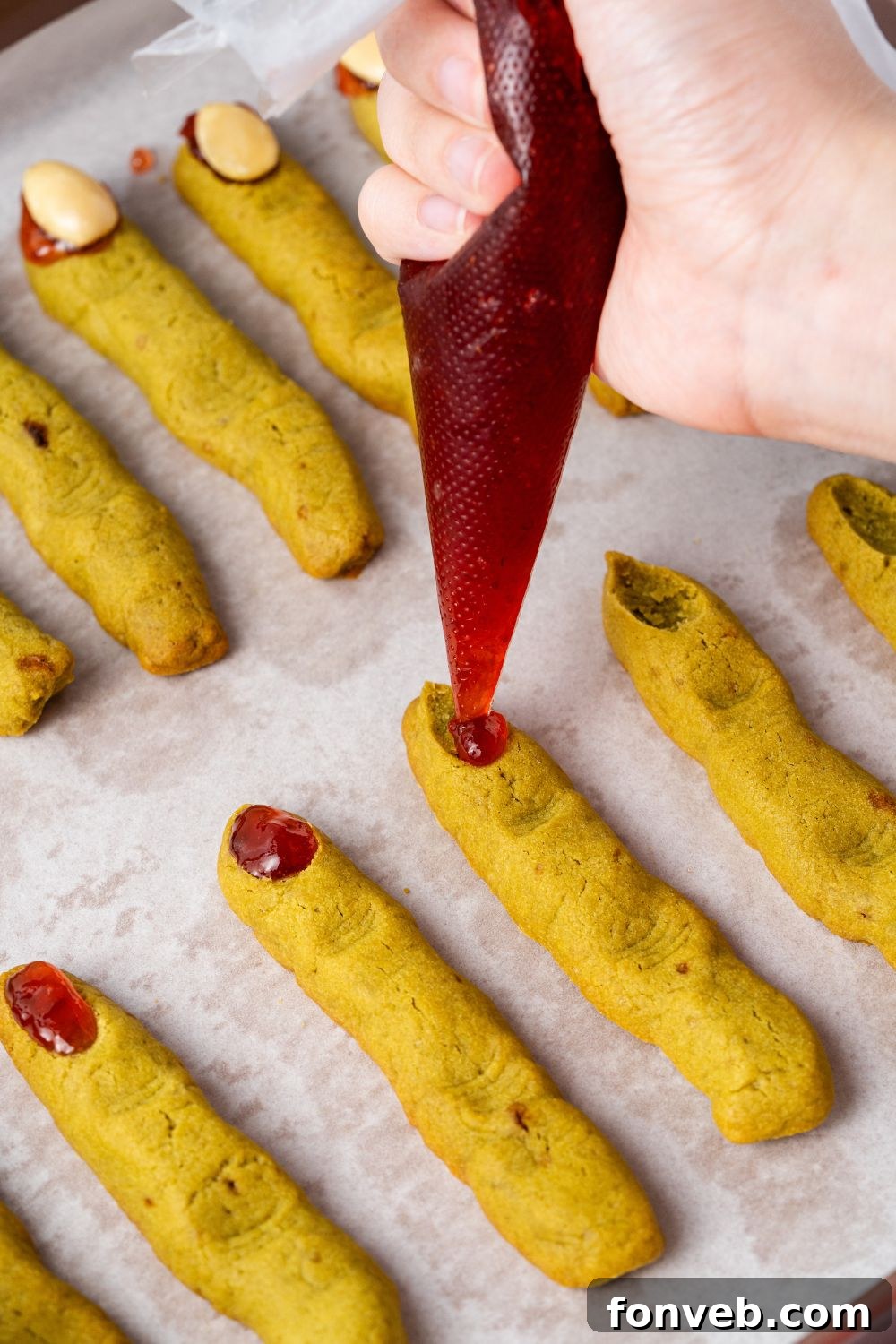 Witch Finger Cookies A Ghoulishly Fun Halloween Bake 12 piping some jam on the tip of each of the Witch Finger Cookies on the baking tray