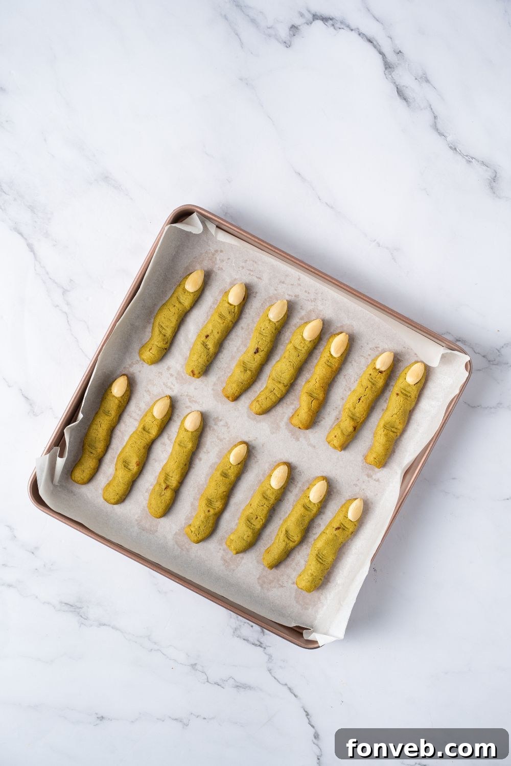 Witch Finger Cookies A Ghoulishly Fun Halloween Bake 14 baked Witch Finger Cookies on a baking sheet with parchment paper on the table