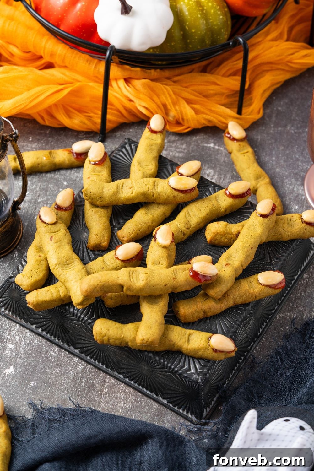 Witch Finger Cookies A Ghoulishly Fun Halloween Bake 21 A Halloween decorated table with a tray full of green Witch Finger Cookies as the center of the picture