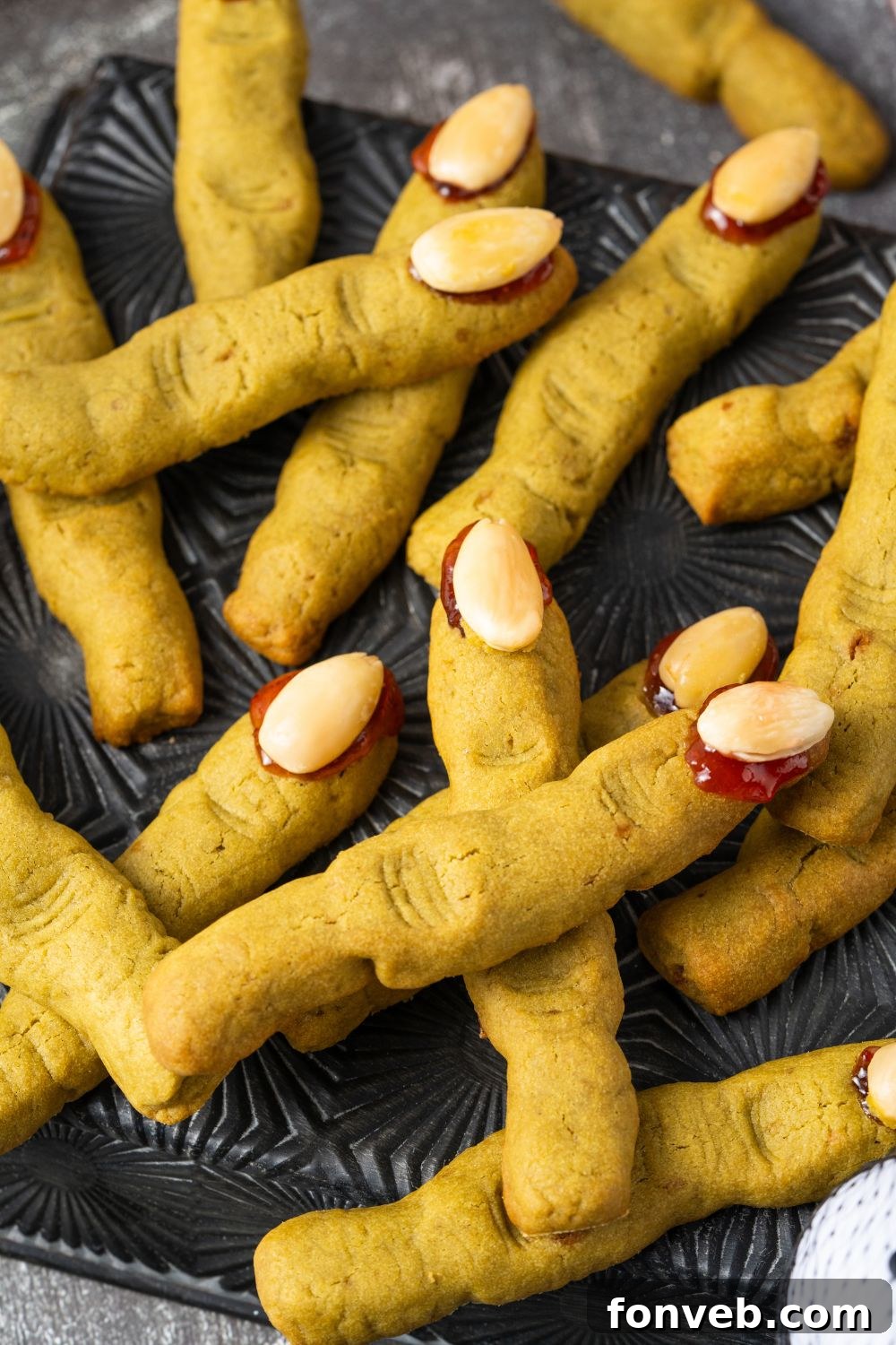 Witch Finger Cookies A Ghoulishly Fun Halloween Bake 22 Witch Finger Cookies placed all around on a black square plate with cookies stacked on top of one another