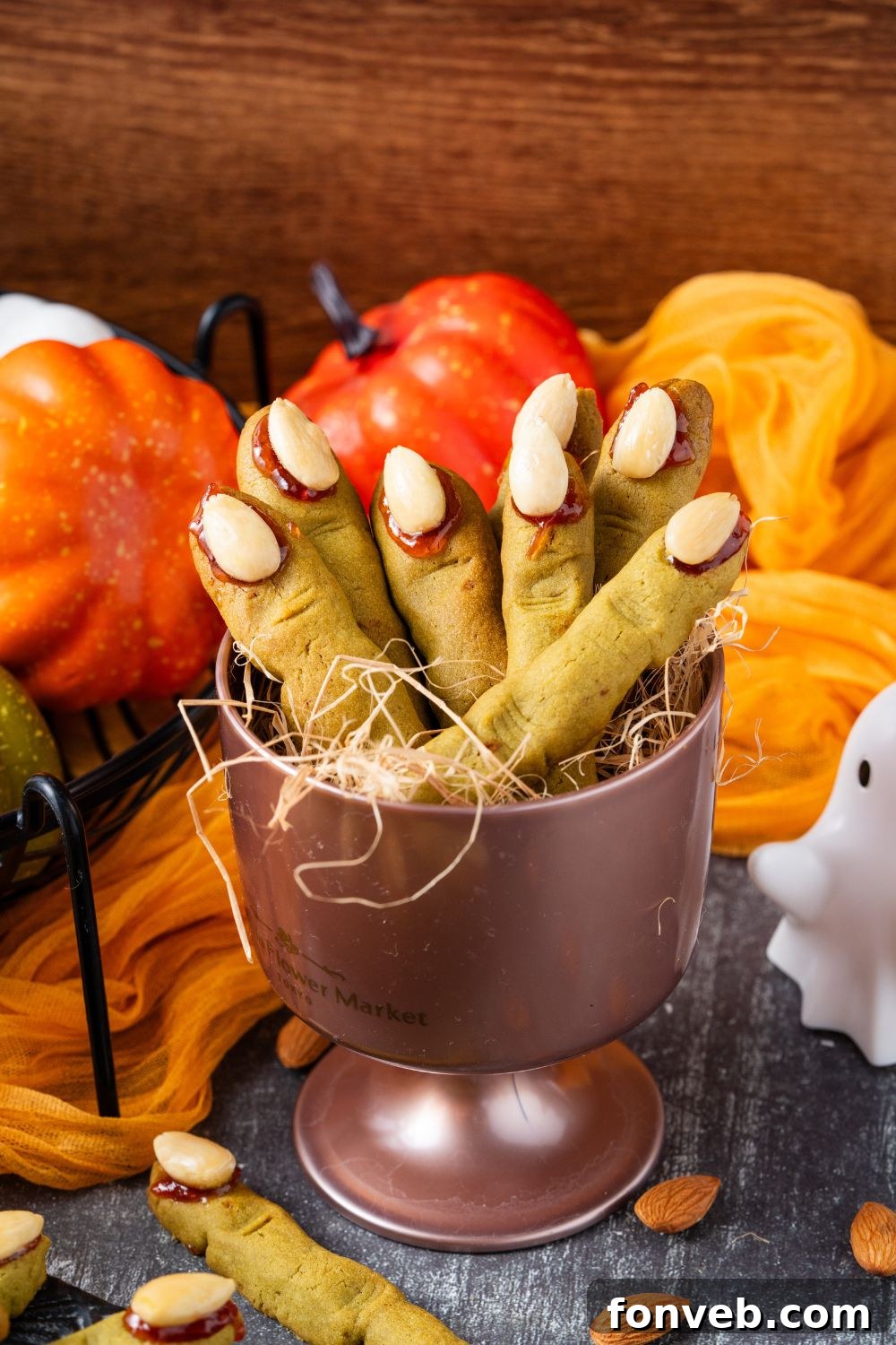 Witch Finger Cookies A Ghoulishly Fun Halloween Bake 24 Witch Finger Cookies in a metal container in the center of a table that is decorated for Halloween