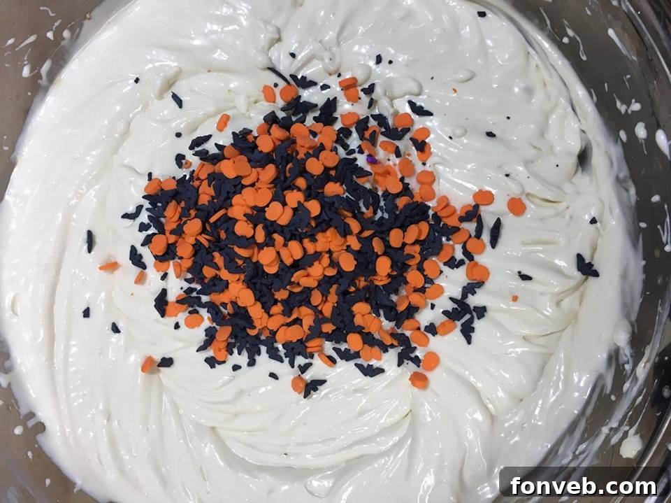 Top-down view of a whole Halloween Funfetti Cheesecake adorned with colorful sprinkles