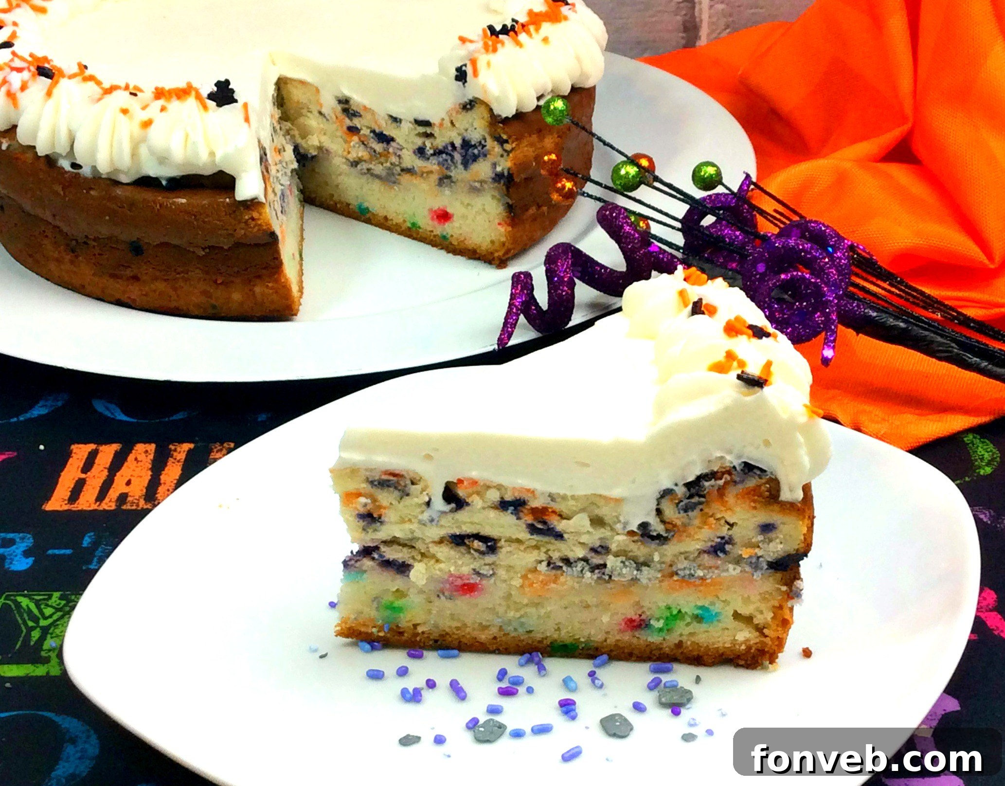 Side view of a tall, layered Halloween Funfetti Cheesecake adorned with spooky sprinkles
