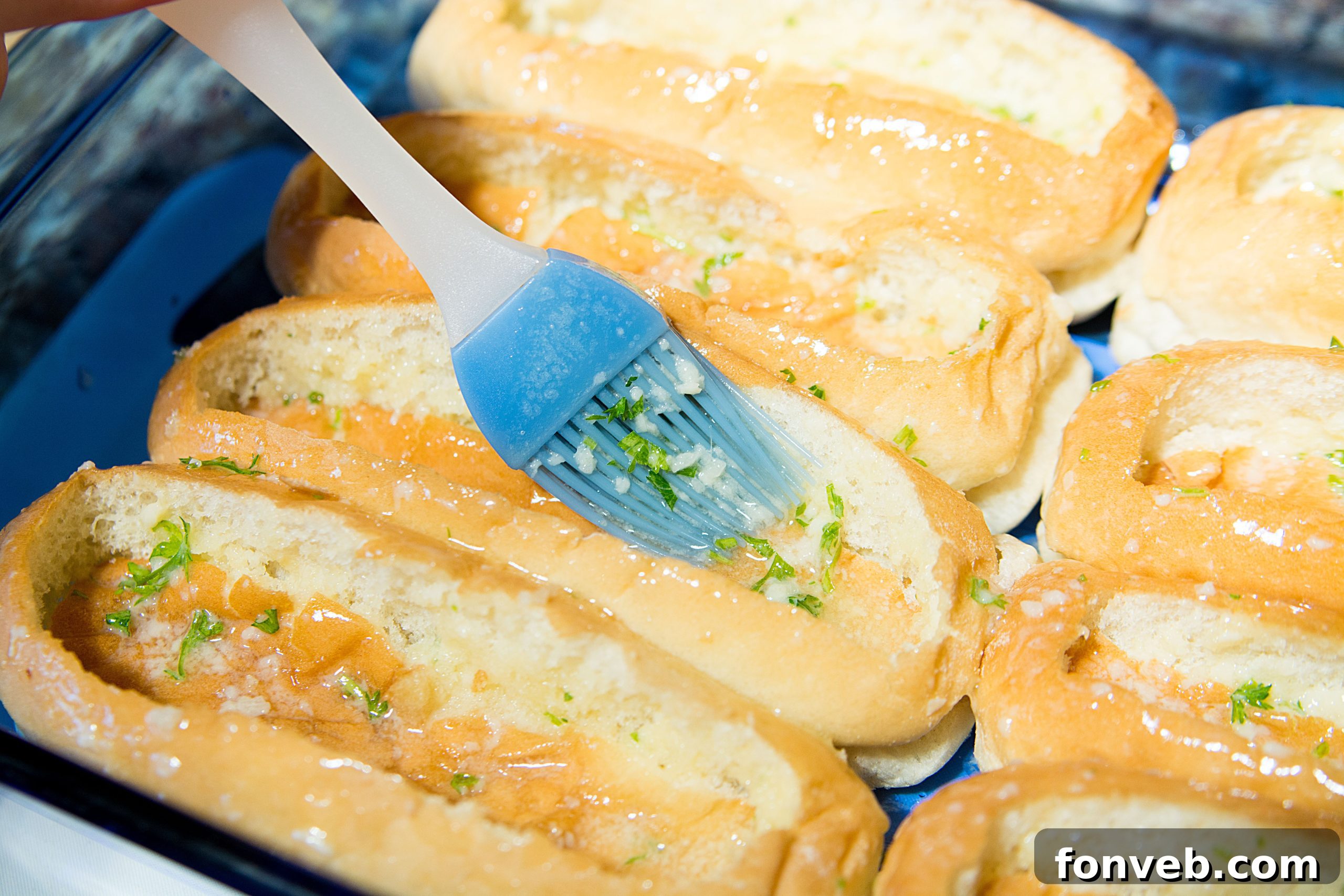 Close-up of hot dog buns after the top sections have been pressed down, showing the created cavities ready for filling.