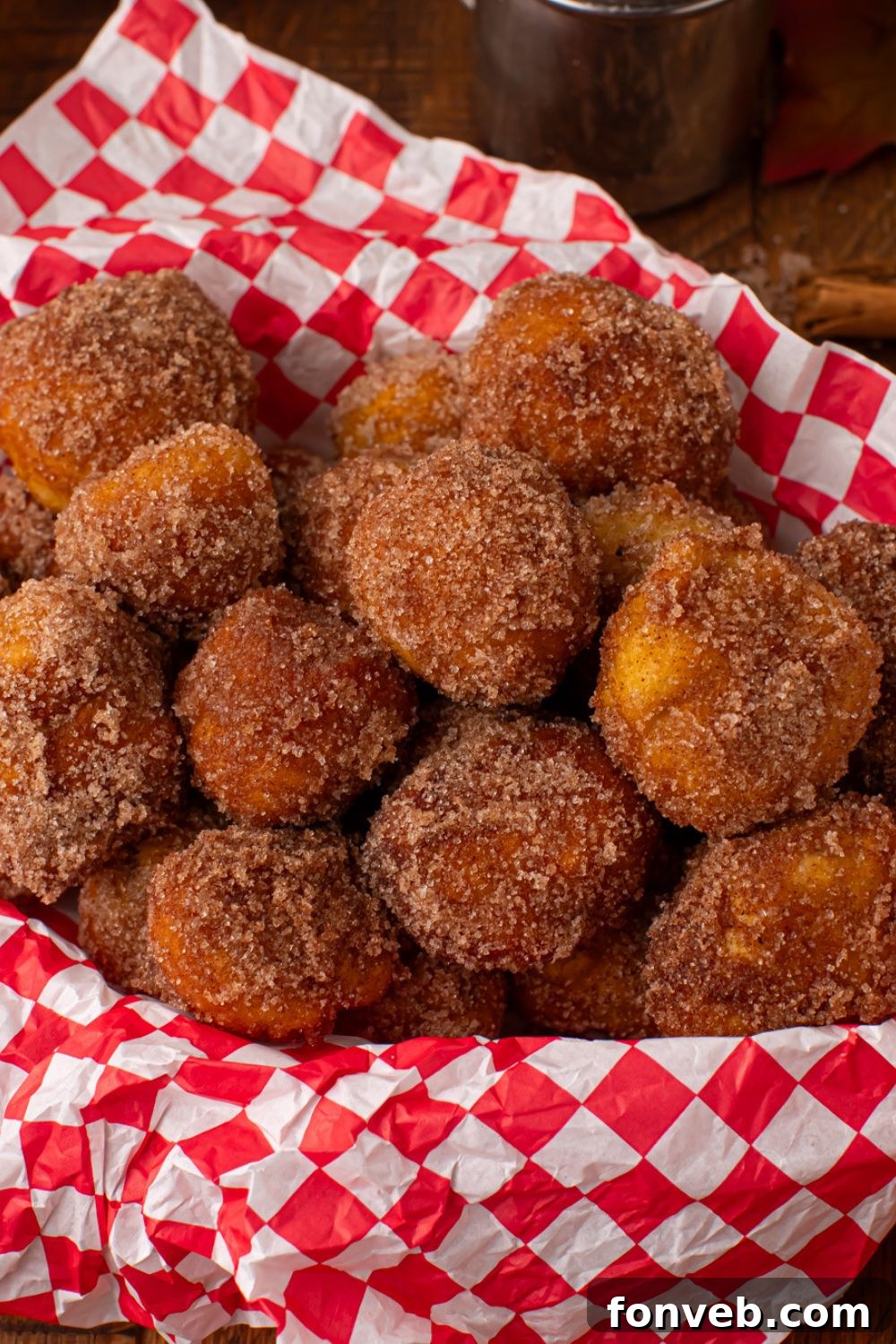 basket with a red checkered liner inside full of a bunch of Apple Pie Donut Holes 