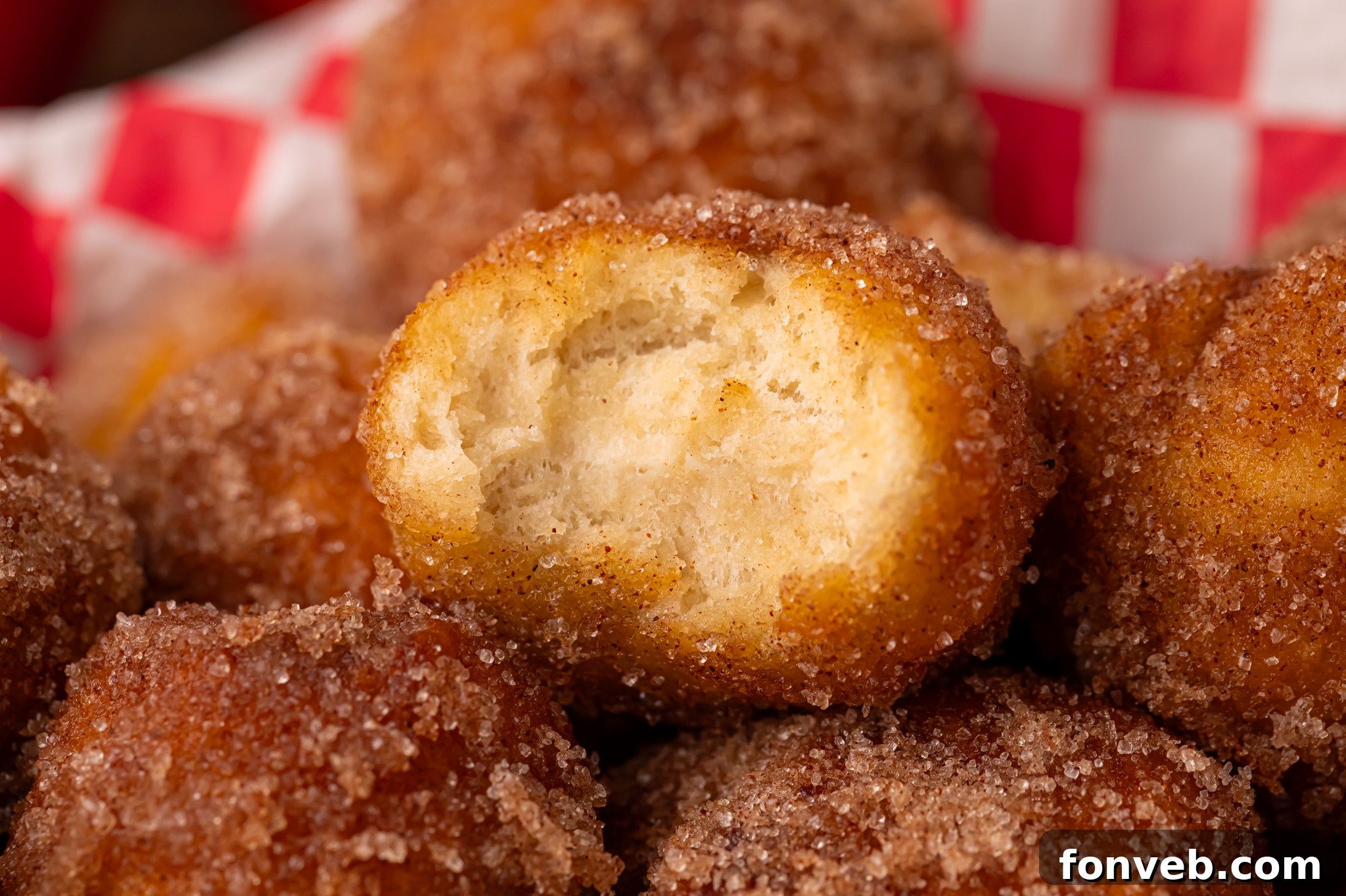 Apple Pie Donut Holes piled in a platter with a bite missing from the top one 
