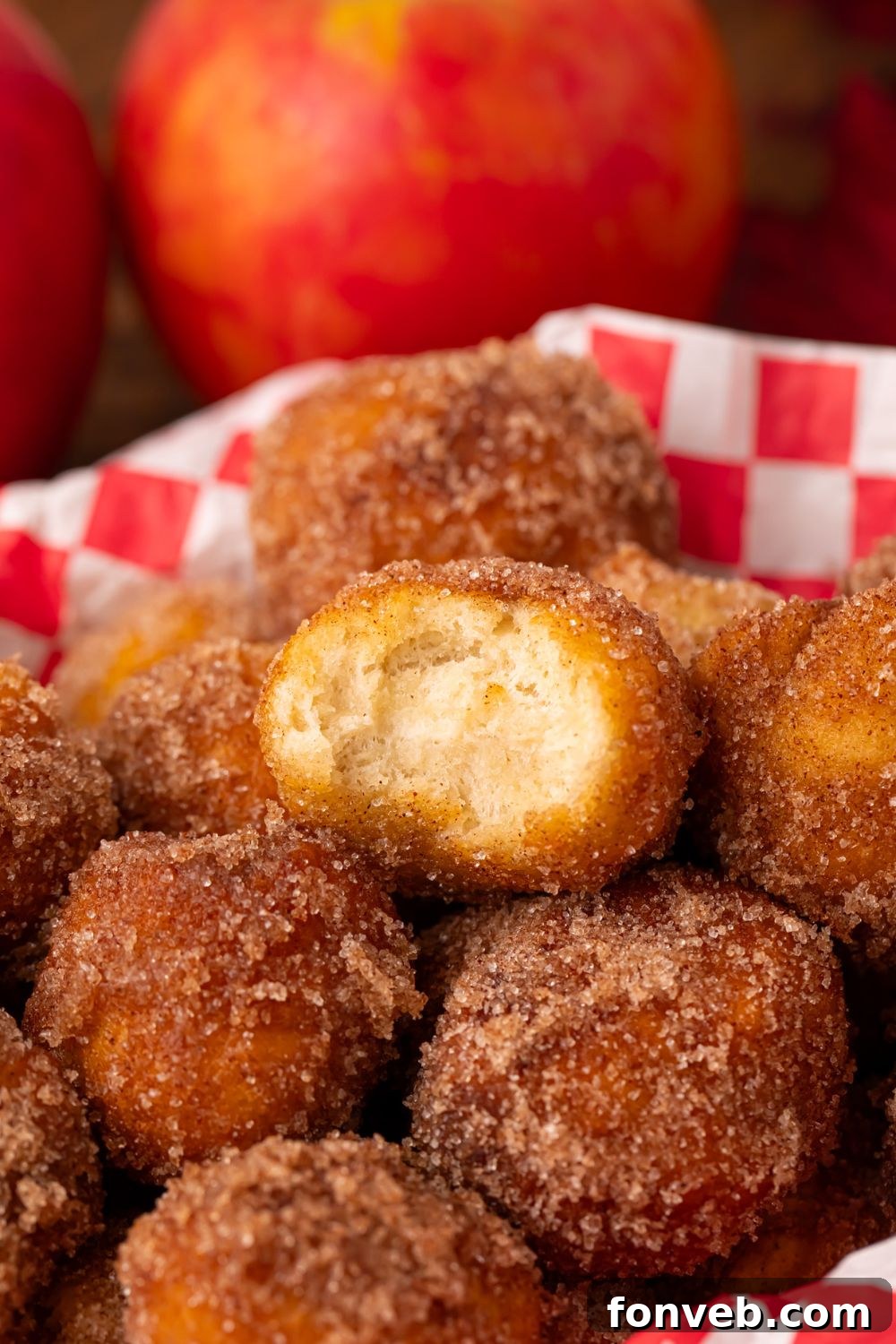 plastic basket with Apple Pie Donut Holes inside and red apples to side of basket