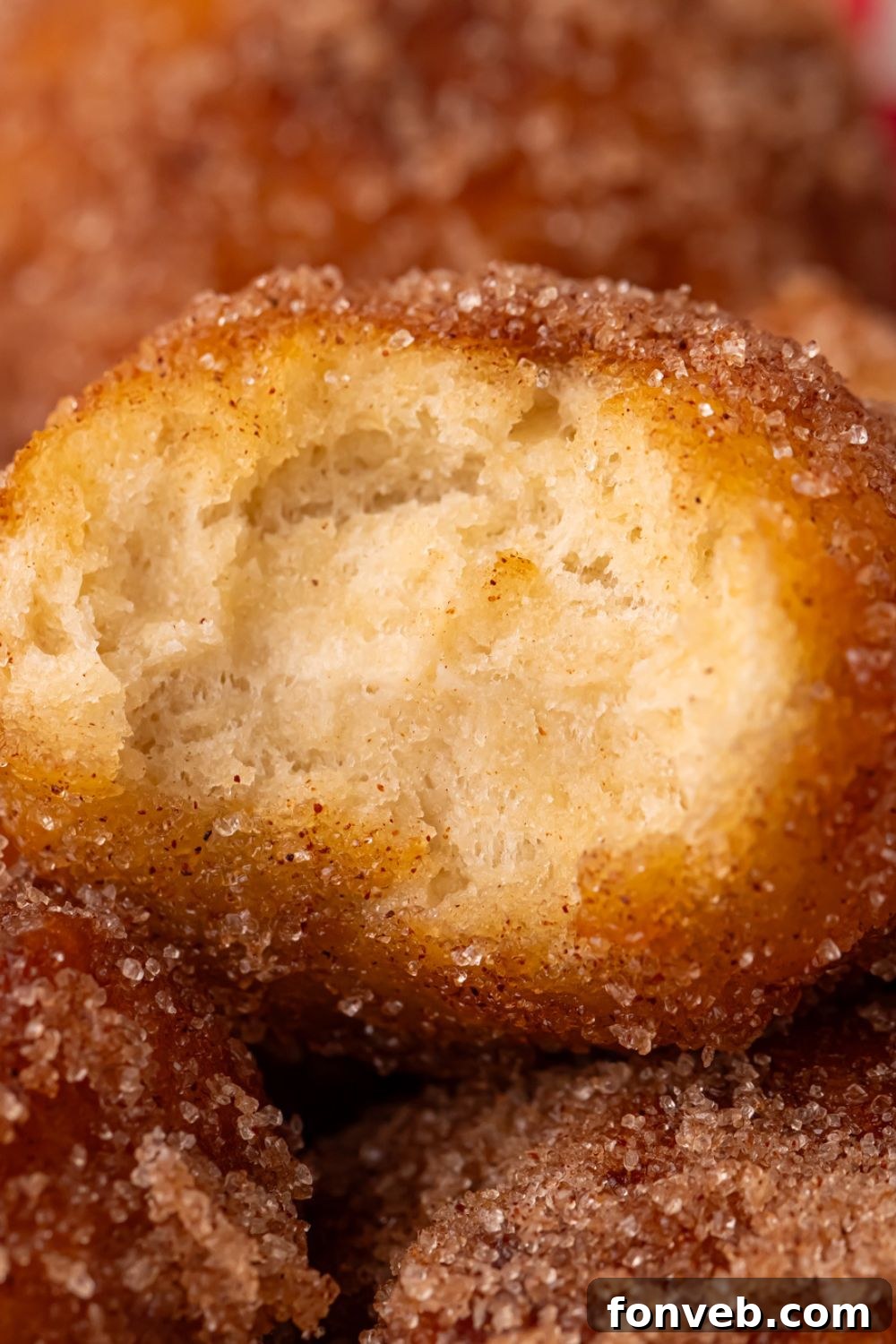 bite taken out of an apple donut hole stacked up on more donut holes