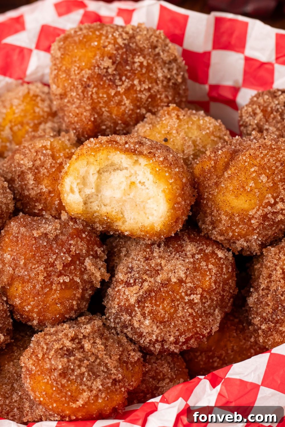 Apple Pie Donut Holes in a basket with a red checked liner sitting on a wooden table 