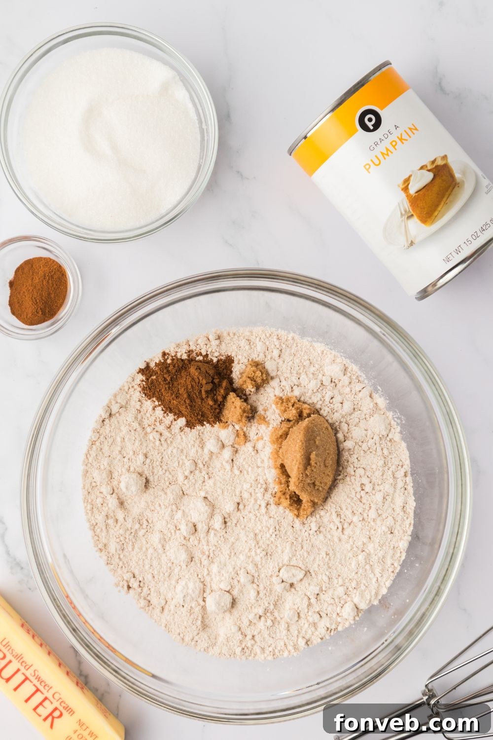 Cinnamon Sugar Baked Pumpkin Spice Donut Holes 5 dry ingredients for making pumpkin donuts in a glass bowl with a can of pumpkin puree to the side and a stick of butter