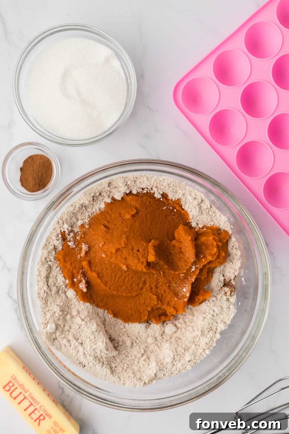 Cinnamon Sugar Baked Pumpkin Spice Donut Holes 6 dry ingredients and pumpkin puree in a glass bowl on a marble counter