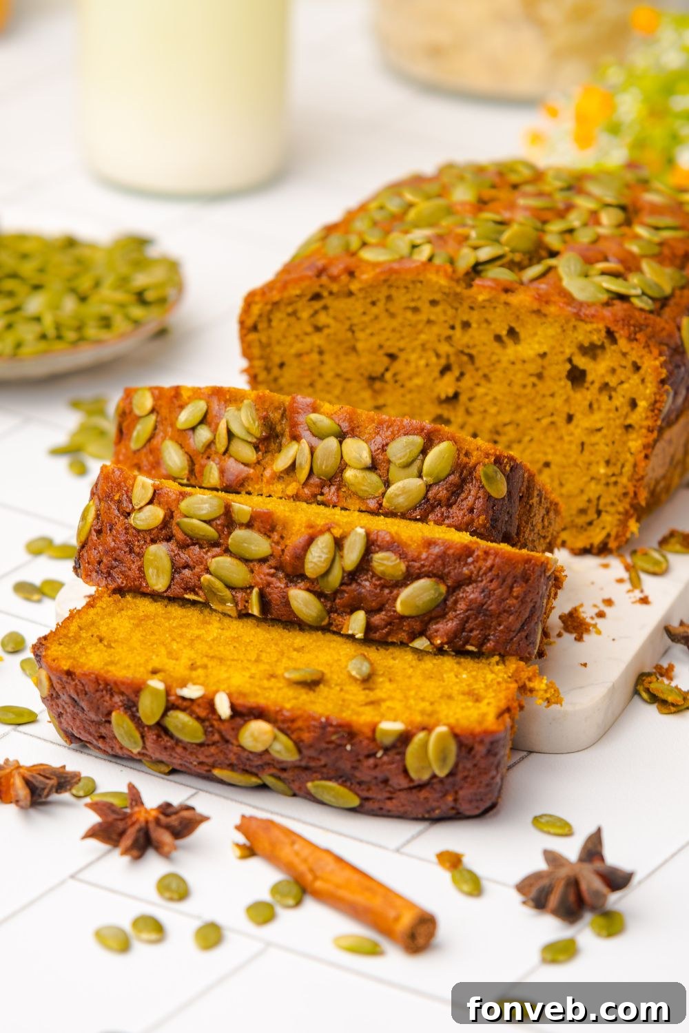 Starbucks Pumpkin Bread placed on table with cinnamon sticks, anise, and pumpkin seeds around the table 