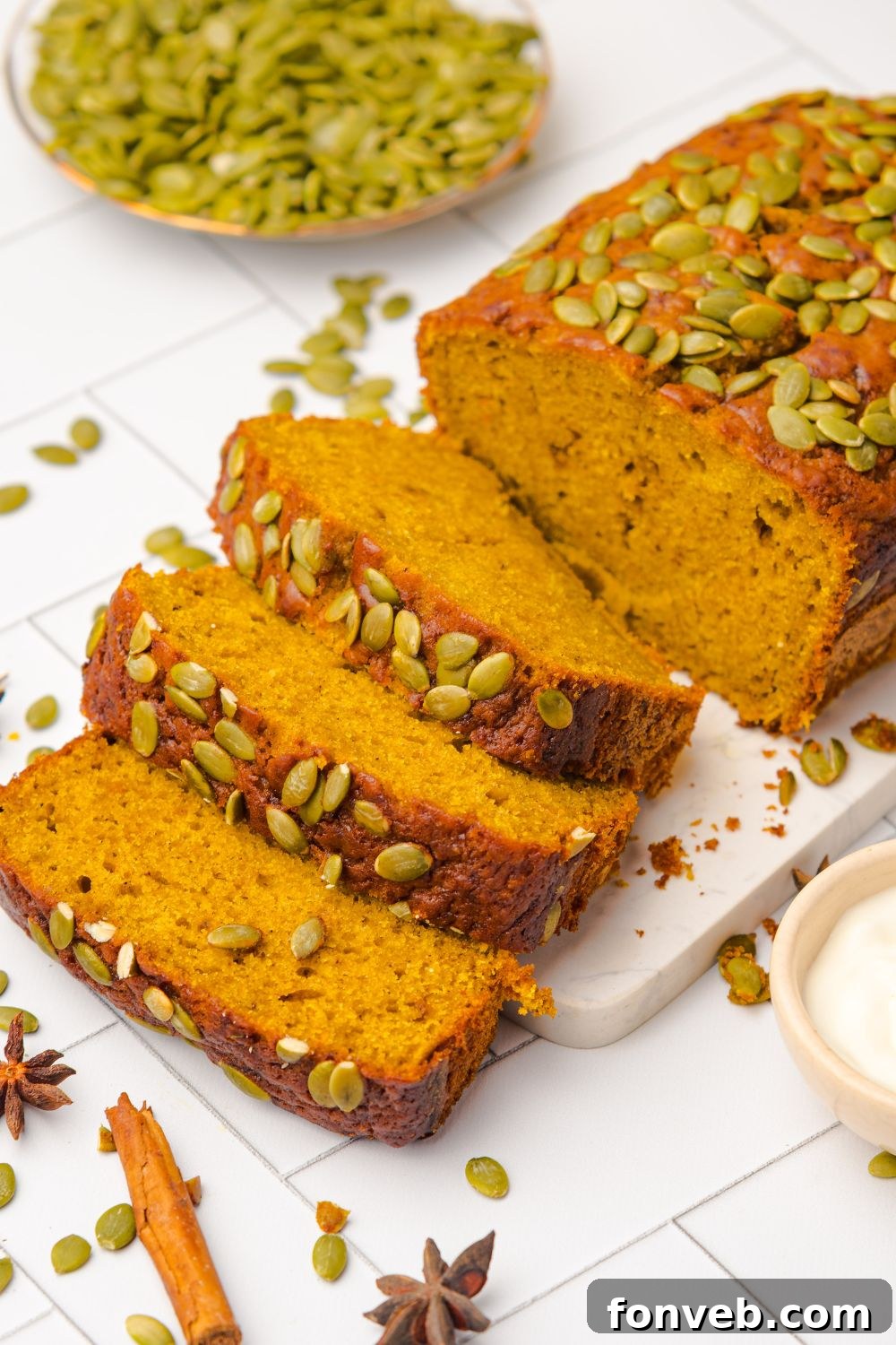 Starbucks Pumpkin Bread on a cutting board, and part of the loaf is sliced into thick slices and laid out on the table 