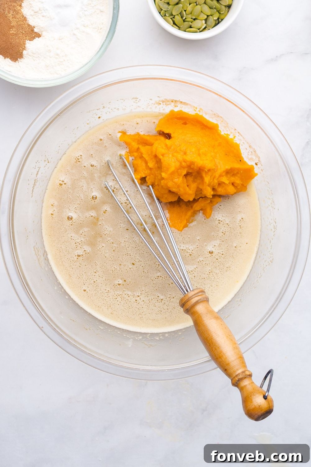 we batter for Starbucks Pumpkin Bread in a glass bowl with a pile of pumpkin puree to side in bowl 