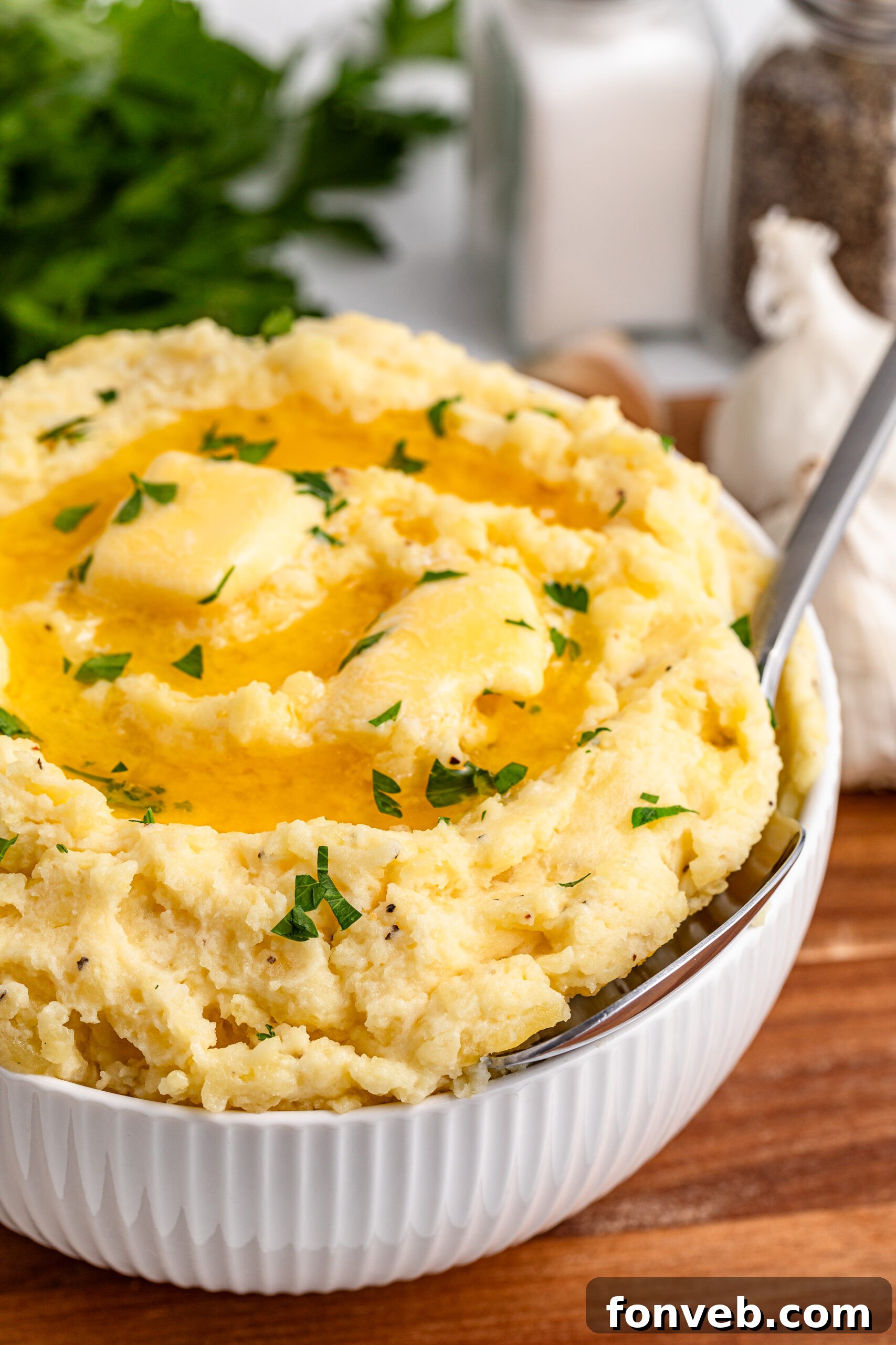 Effortless Creamy Garlic Mashed Potatoes 22 Garlic mashed potatoes in a white bowl on a dark wood table