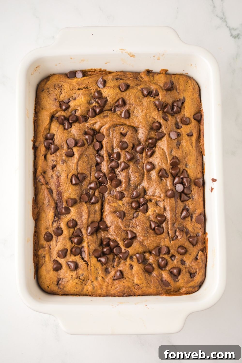 Brown Butter Pumpkin Chocolate Chip Bars in a white pan on table 