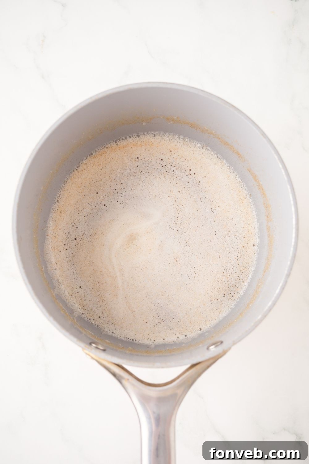 brown butter in a metal sauce pan sitting on the table 