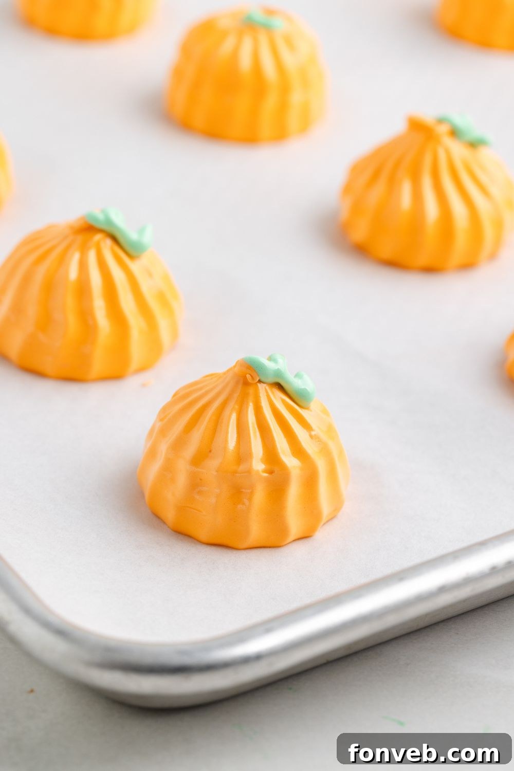 Pumpkin Meringues piped onto a metal baking sheet lined with parchment paper 