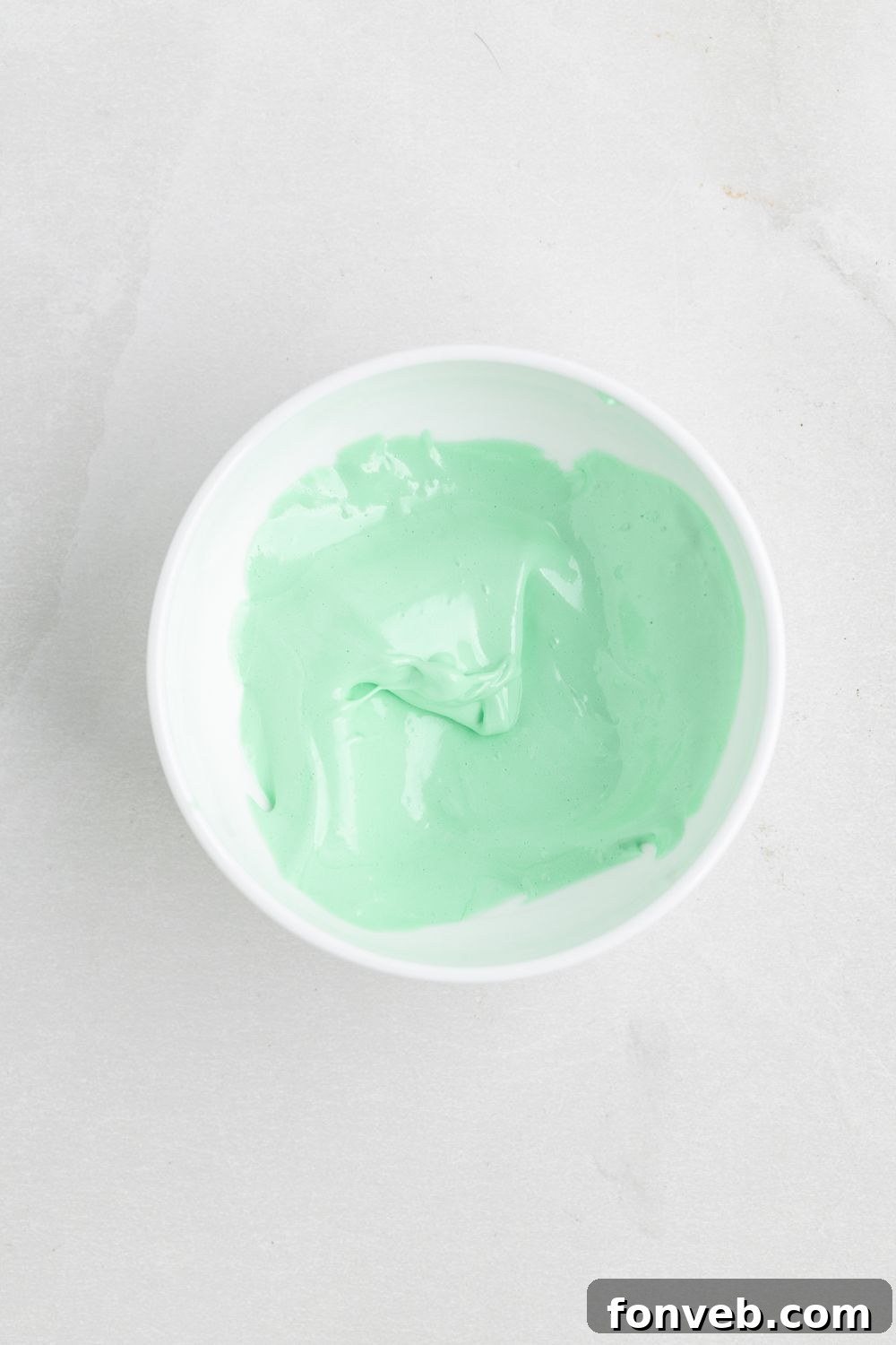 green colored meringue in a white bowl on the table 