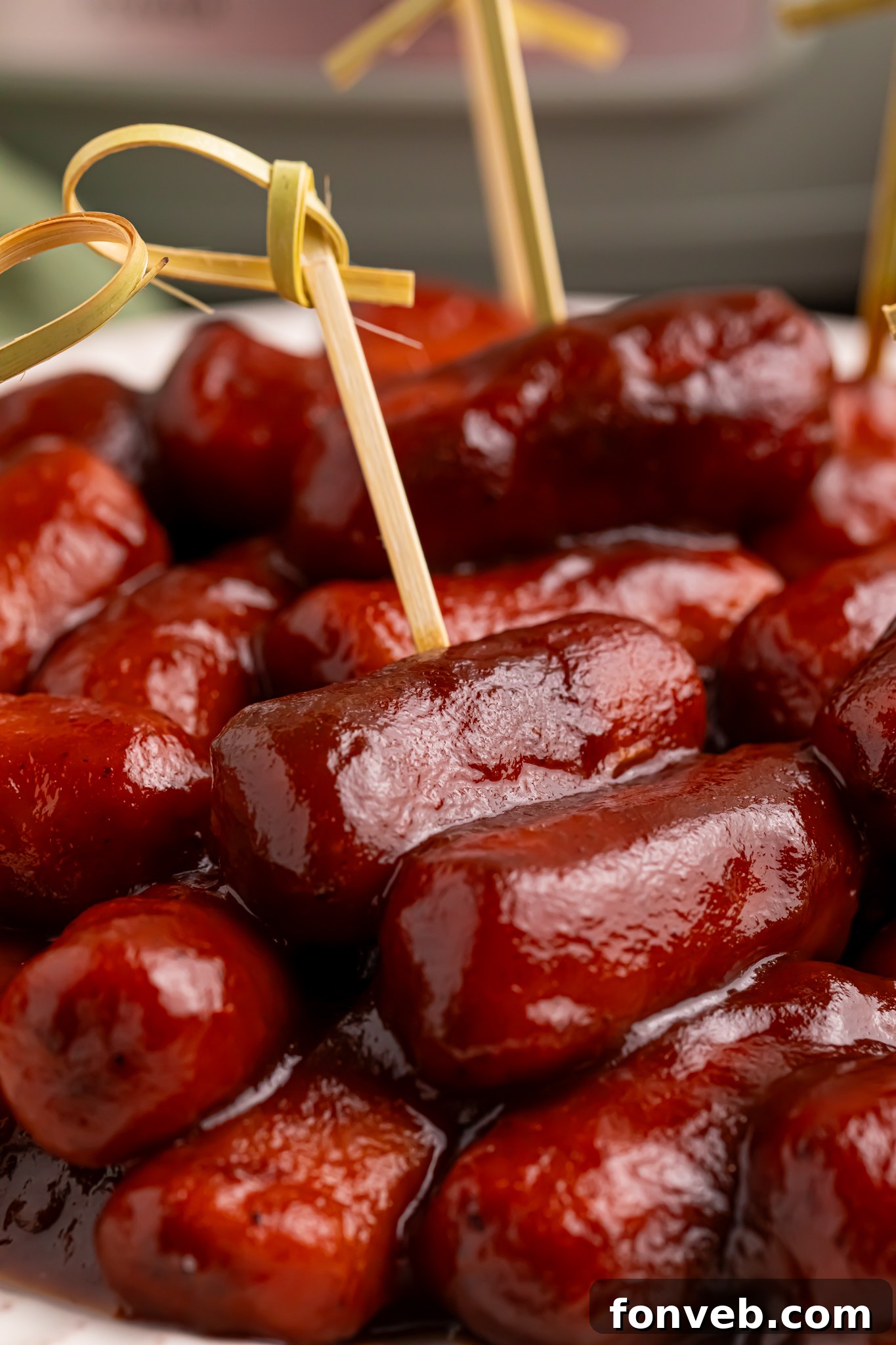 Sweet and Tangy Crockpot Apple Butter Smokies 20 Apple Butter smokies on a white platter with toothpicks in them