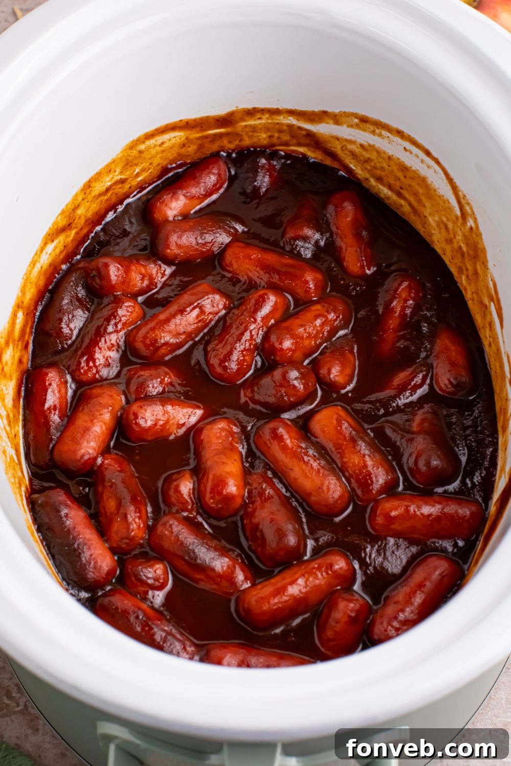 Sweet and Tangy Crockpot Apple Butter Smokies 10 white crockpot full of bbq and apple butter coated little smokies