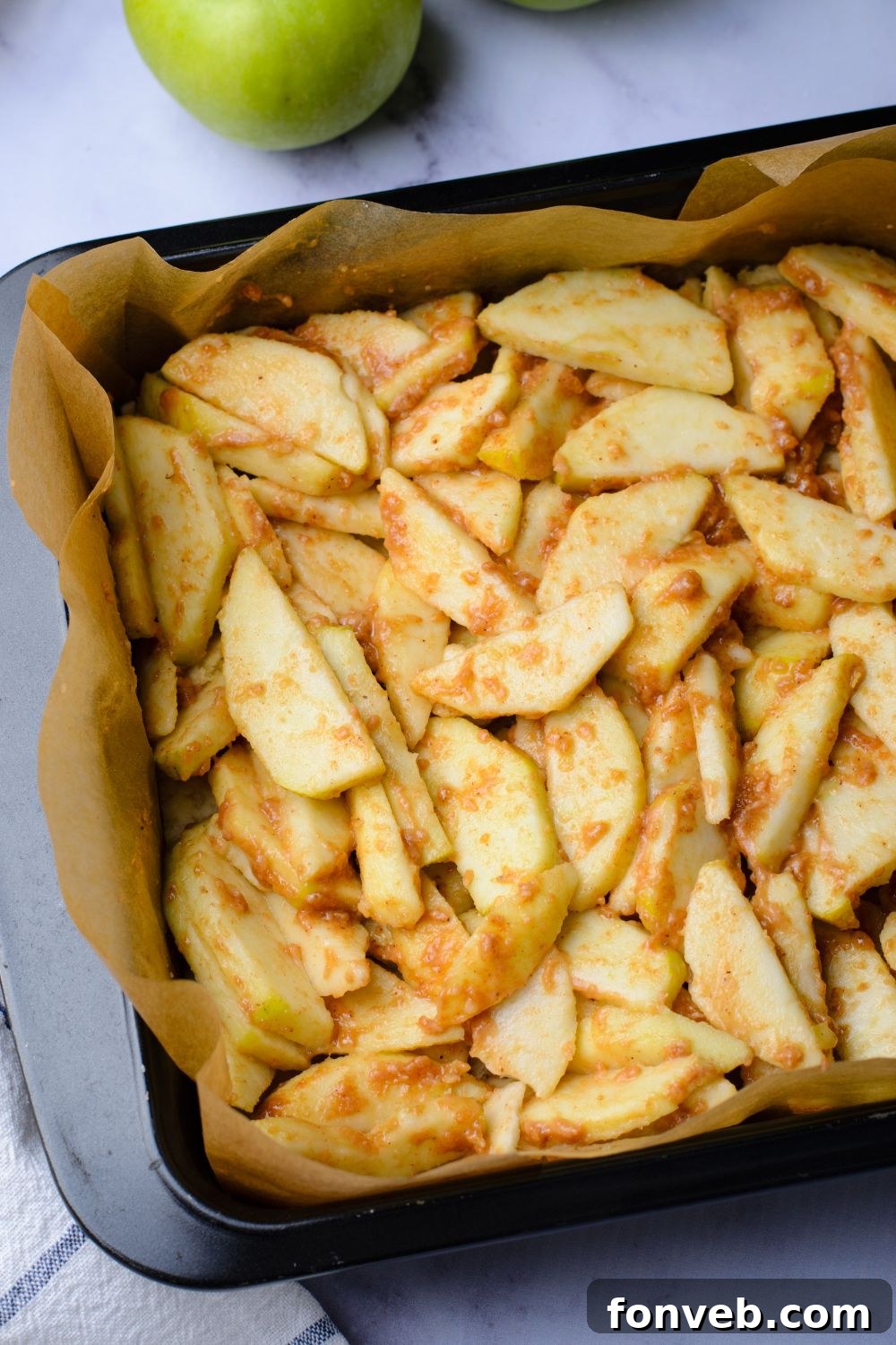 sliced apples that are seasoned in a pan on table