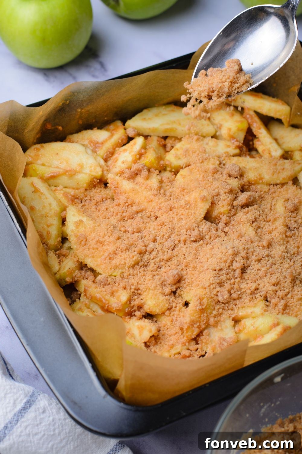 a pan with apples with a crumble topping on top