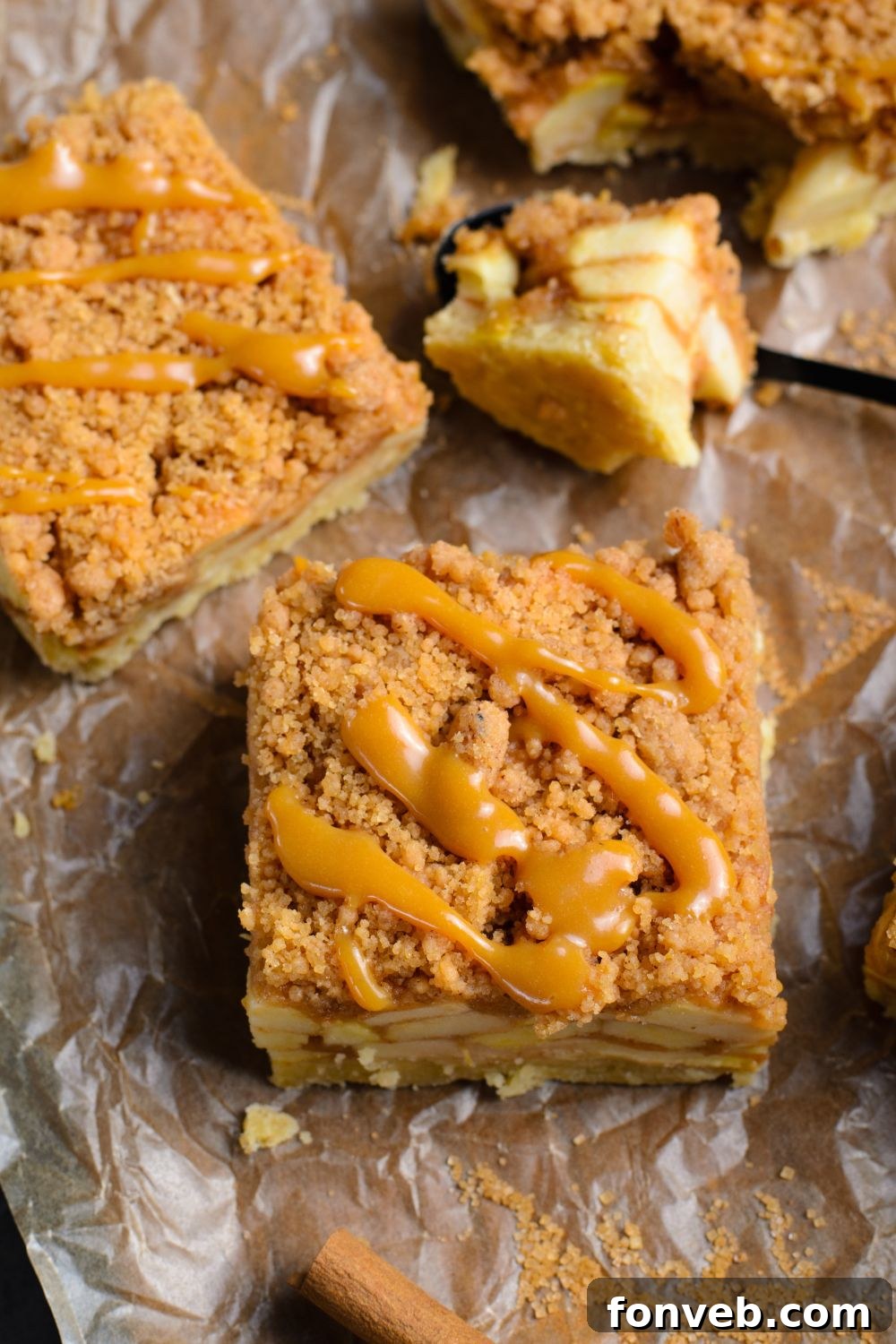 a few apple bars on table with parchment paper with caramel sauce drizzled on each bar