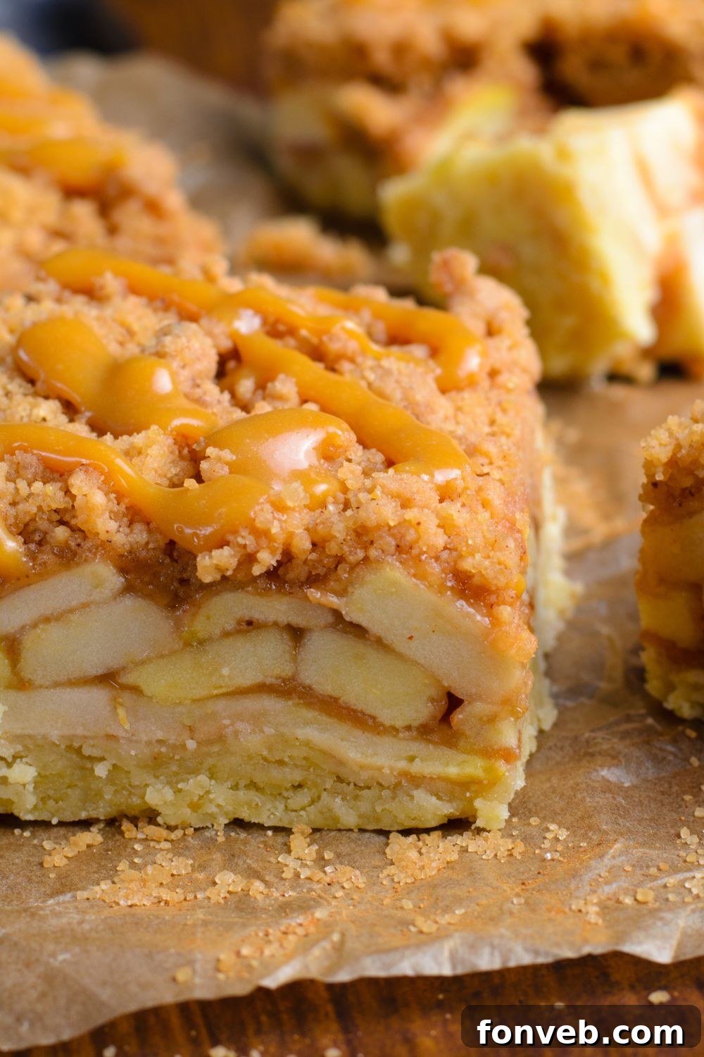 Caramel Apple Pie Bar placed on parchment paper showing apples in the center of the bars