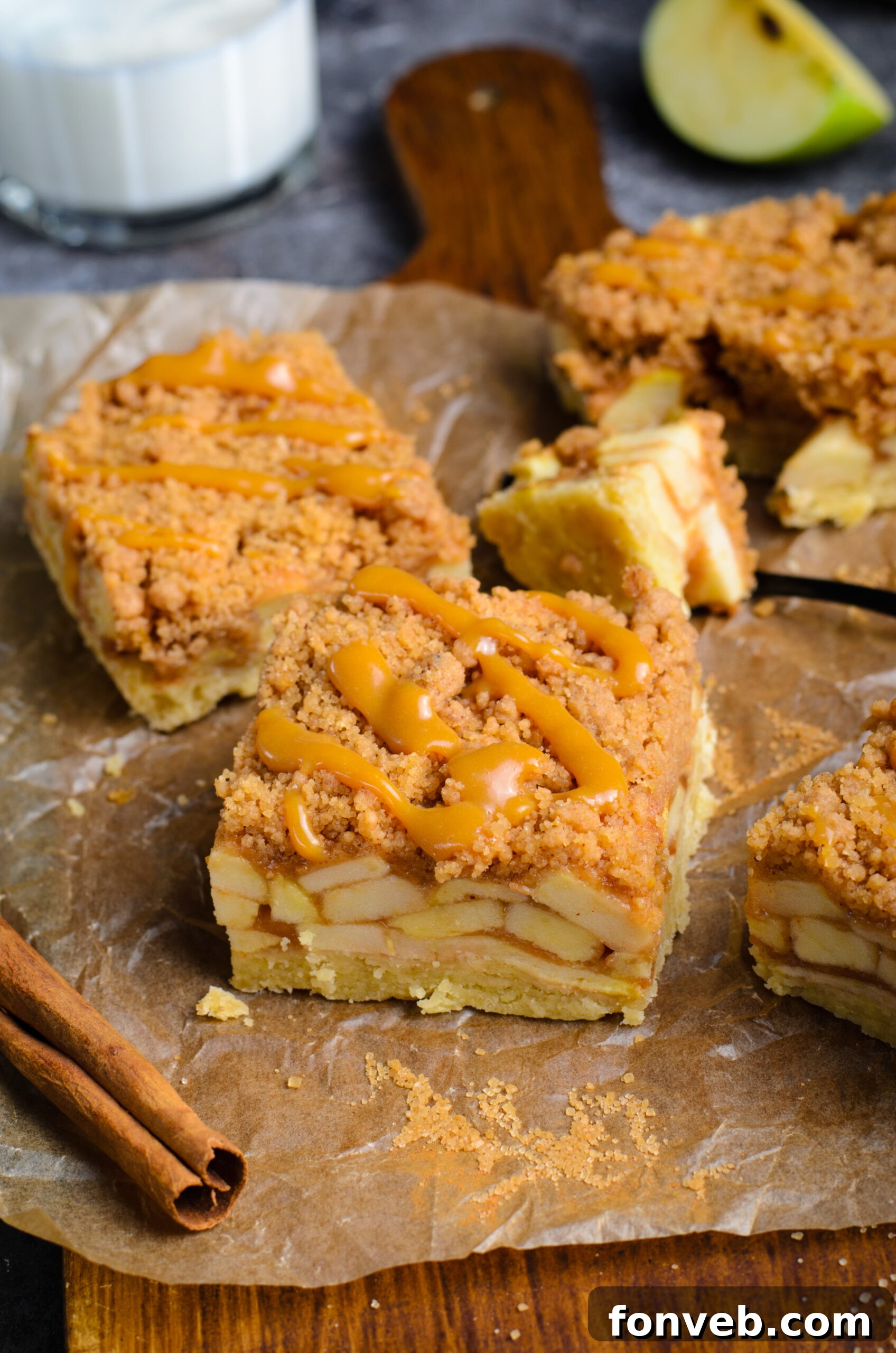 Caramel Apple Pie Bars on placed on brown parchment paper showing apples in the center of the bars