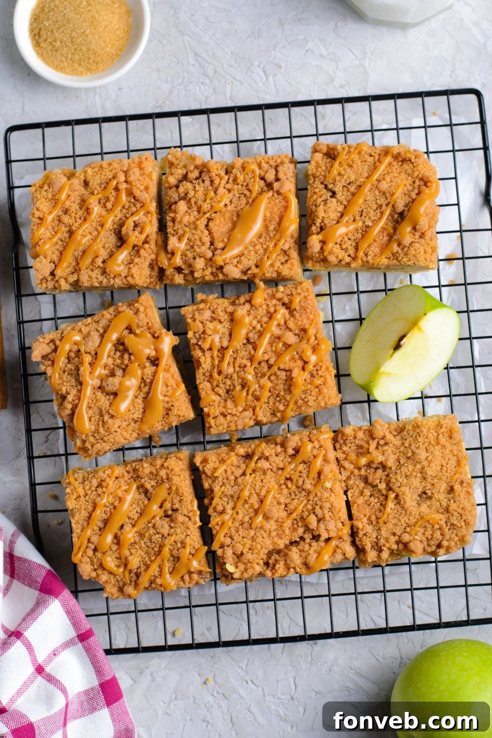 Caramel Apple Pie Bars on a cooling rack cut into squares with an apple slice to side