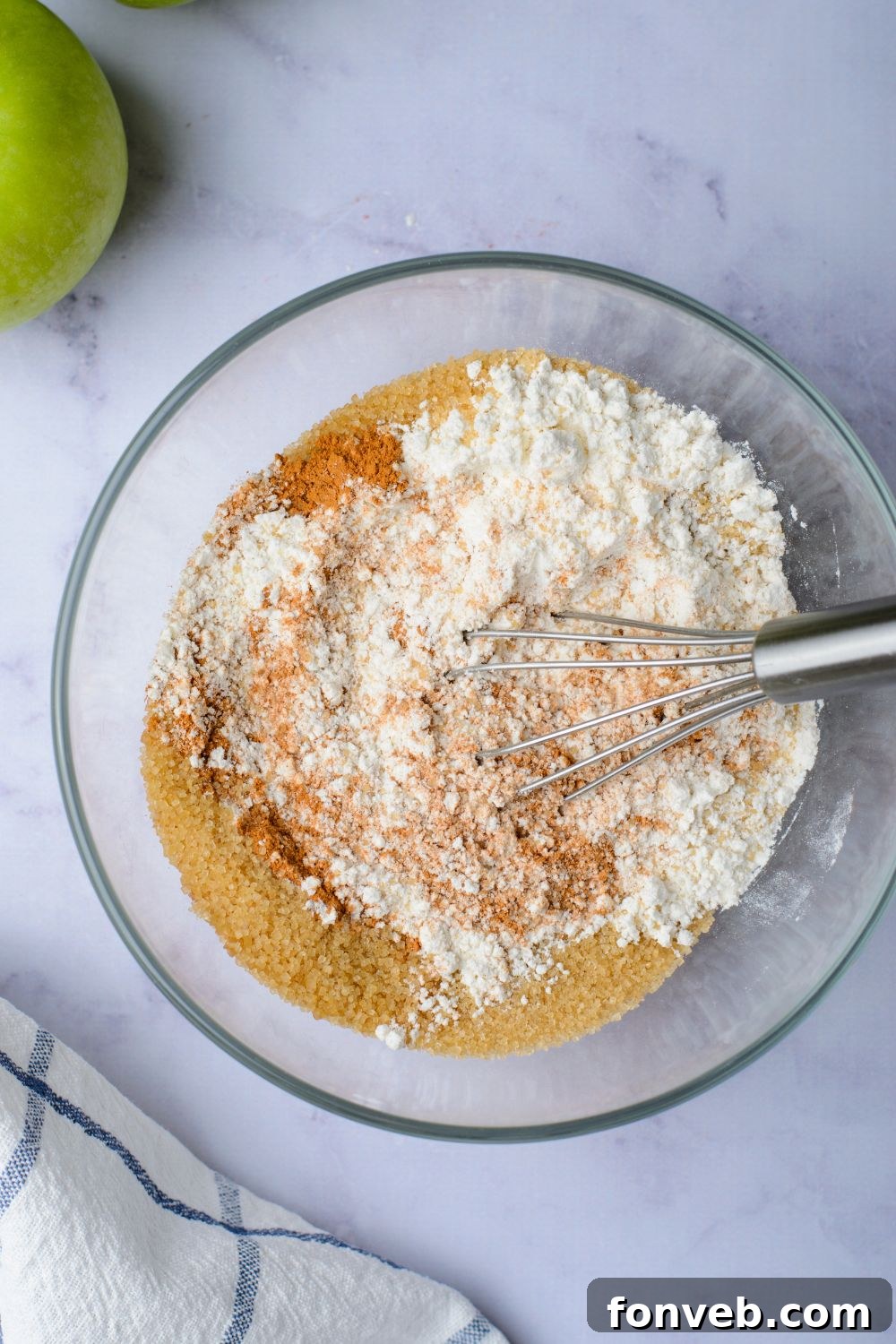 flour mixture with spices in a glass bowl with a whisk