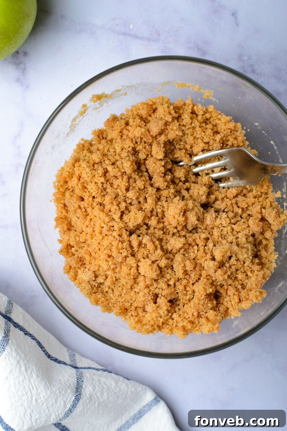 brown sugar crumble in a glass bowl with a fork to side