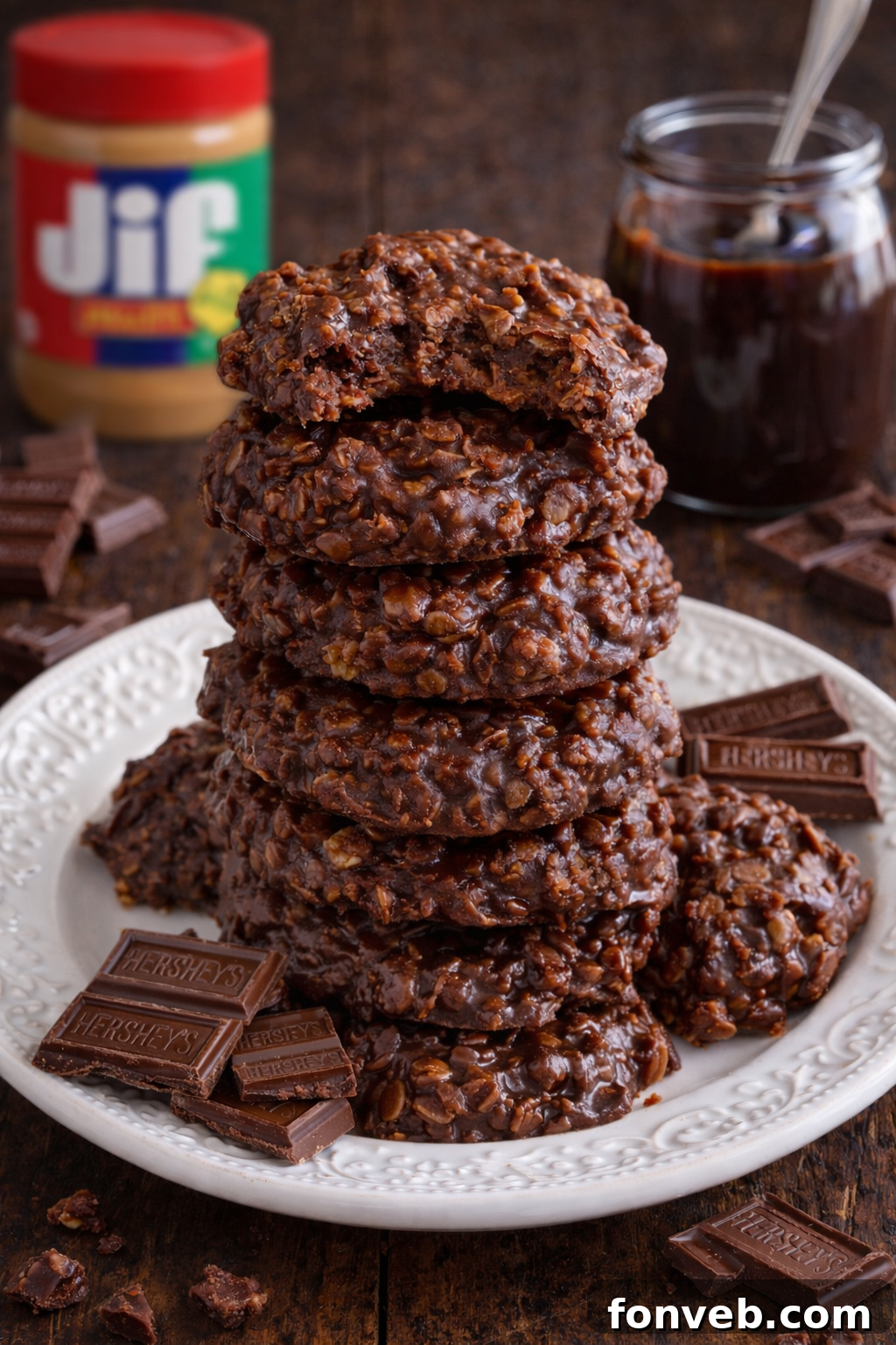 Chocolate Peanut Butter No Bake Cookies on a white plate stacked with a bite missing from the top one