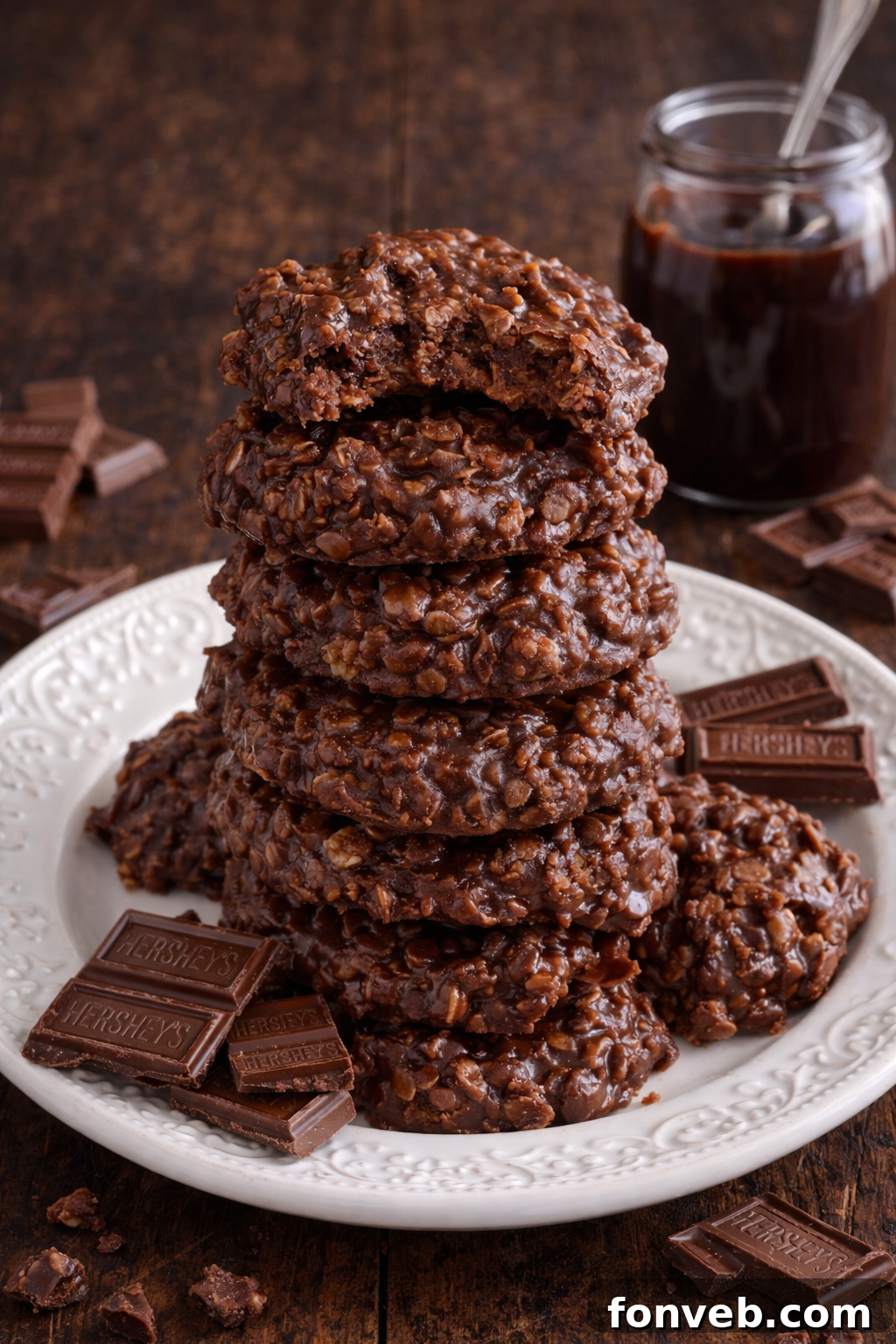 Chocolate Peanut Butter No Bake Cookies on a white plate stacked with a bite missing from the top one