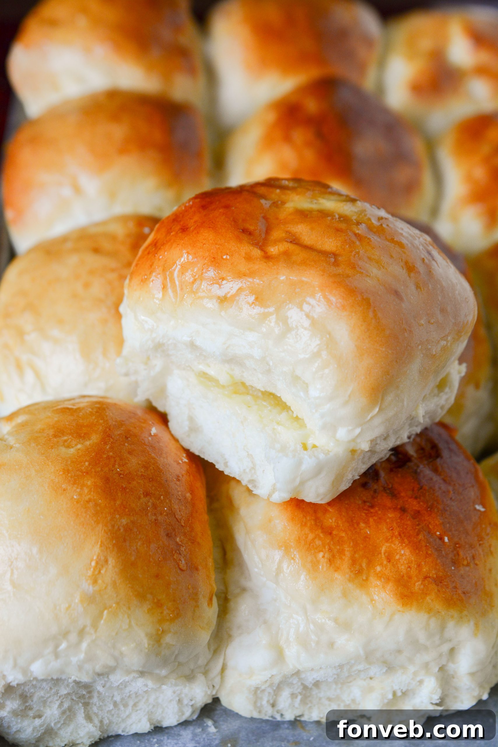 Close-up of a stack of fluffy, light brown dinner rolls.