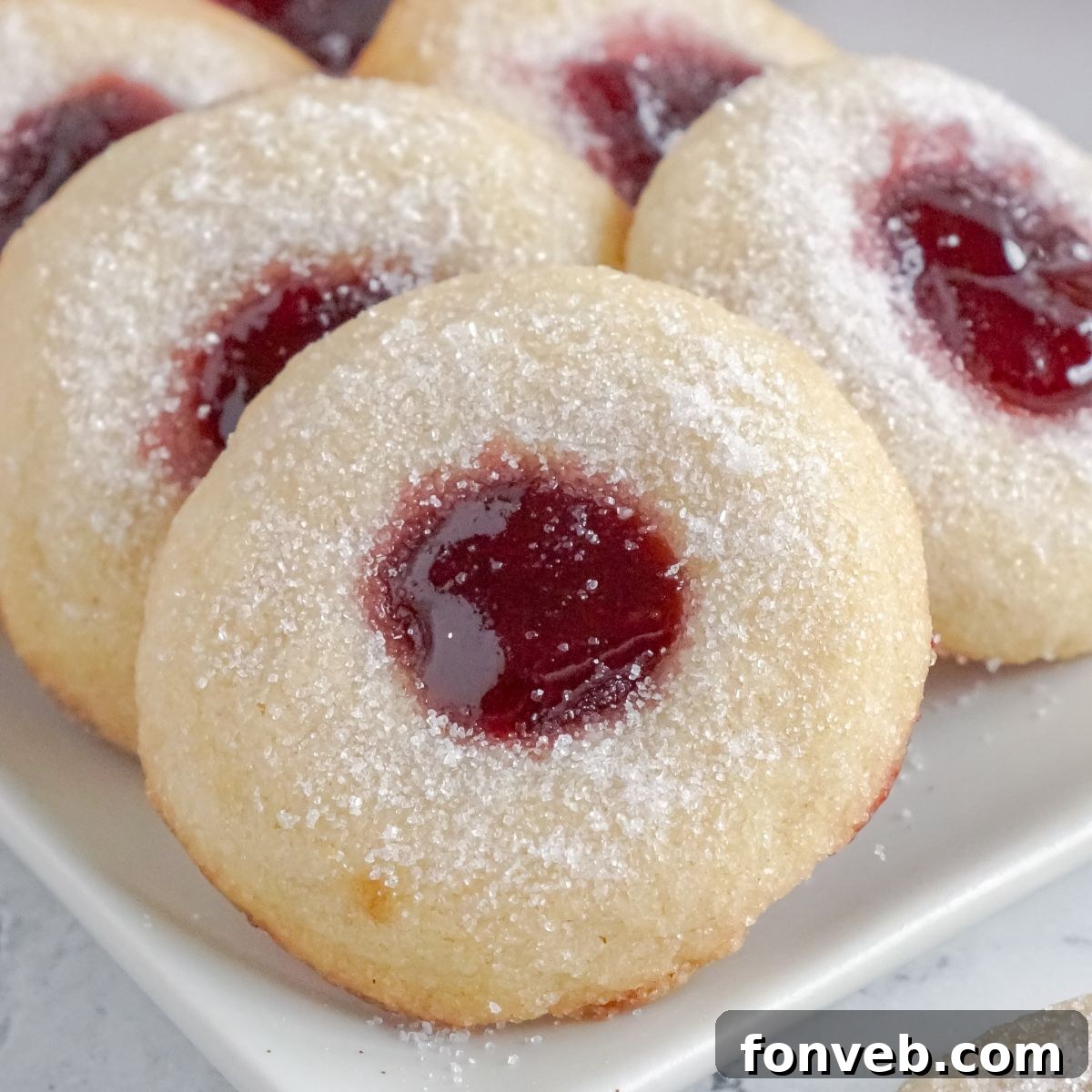 Raspberry Thumbprint Cookies on a white platter on the table