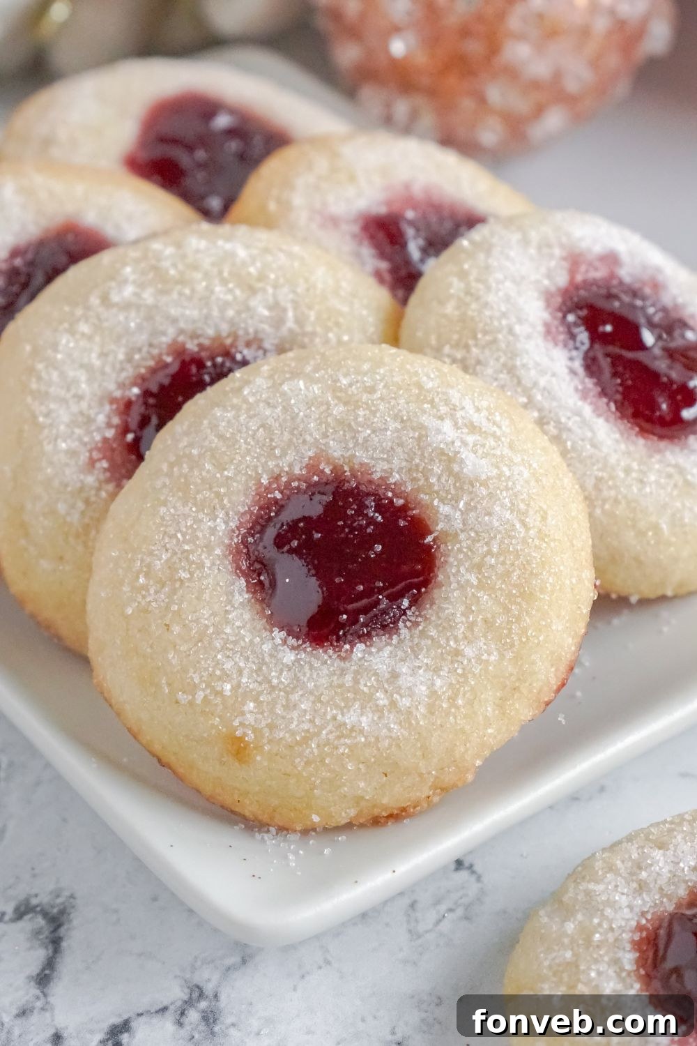 Raspberry Thumbprint Cookies on a platter on a marble counter