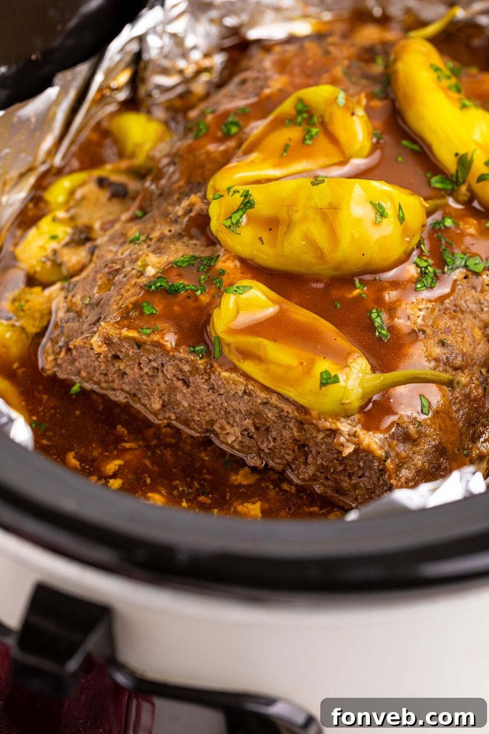 close up of Crockpot Mississippi Meatloaf with peppers and gravy on top