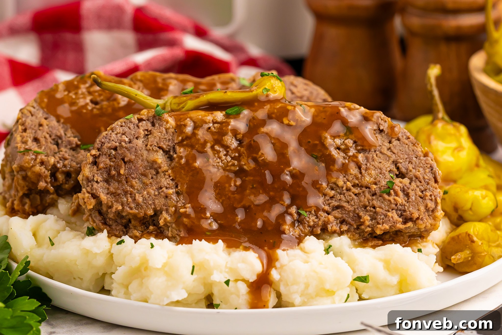 Crockpot Mississippi Meatloaf on a white plate on top of fluffy mashed potatoes