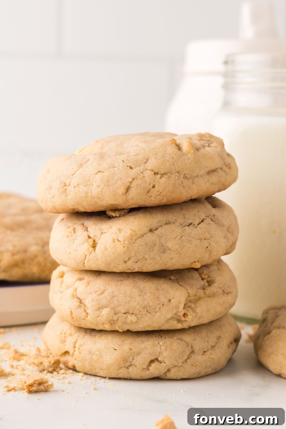 New York cheesecake cookies in a stack on table with a jar of milk behind it on table