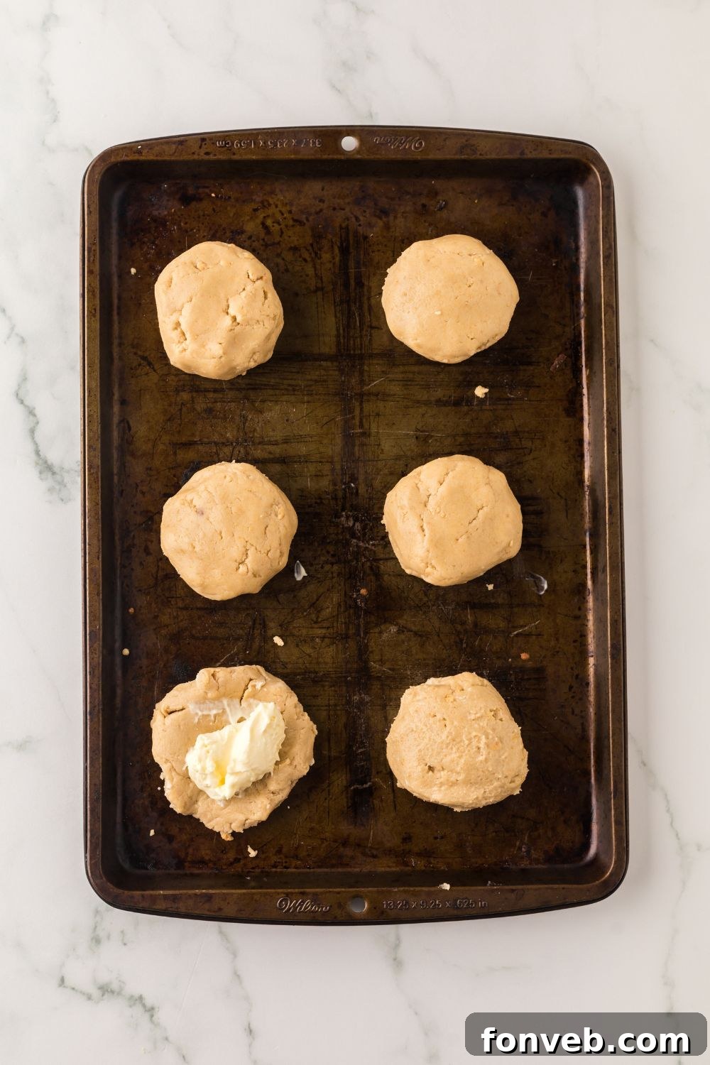 cheesecake cookie in raw dough on table with cheesecake in the center of table