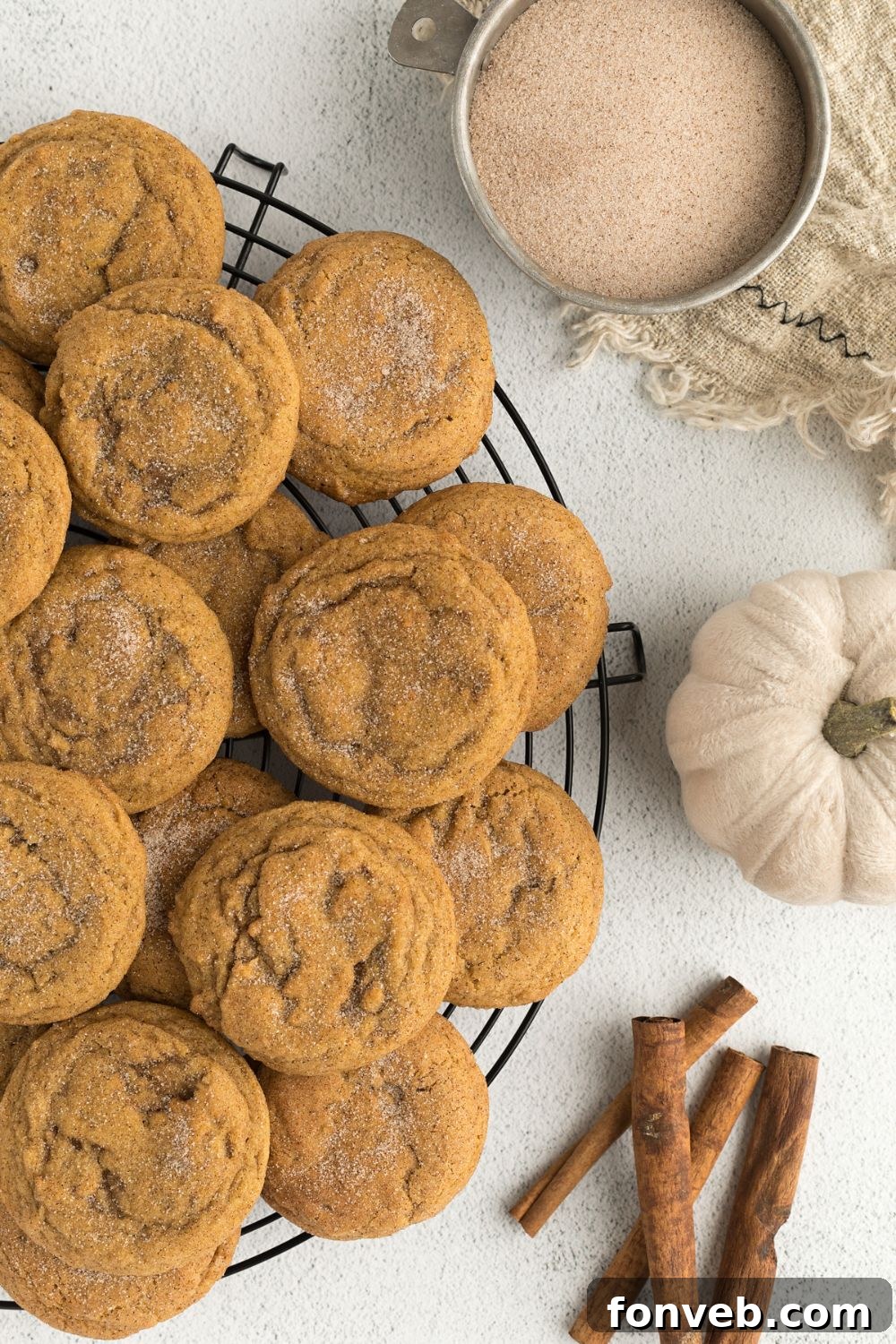 Spiced Pumpkin Snickerdoodle Cookies 12 Pumpkin Snickerdoodle Cookies on a platter with sugar, pumpkin and cinnamon sticks to the side