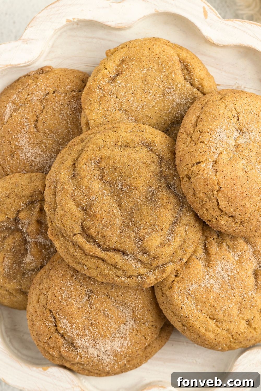 Spiced Pumpkin Snickerdoodle Cookies 16 Pumpkin Snickerdoodle Cookies piled on a plate sitting on a white table