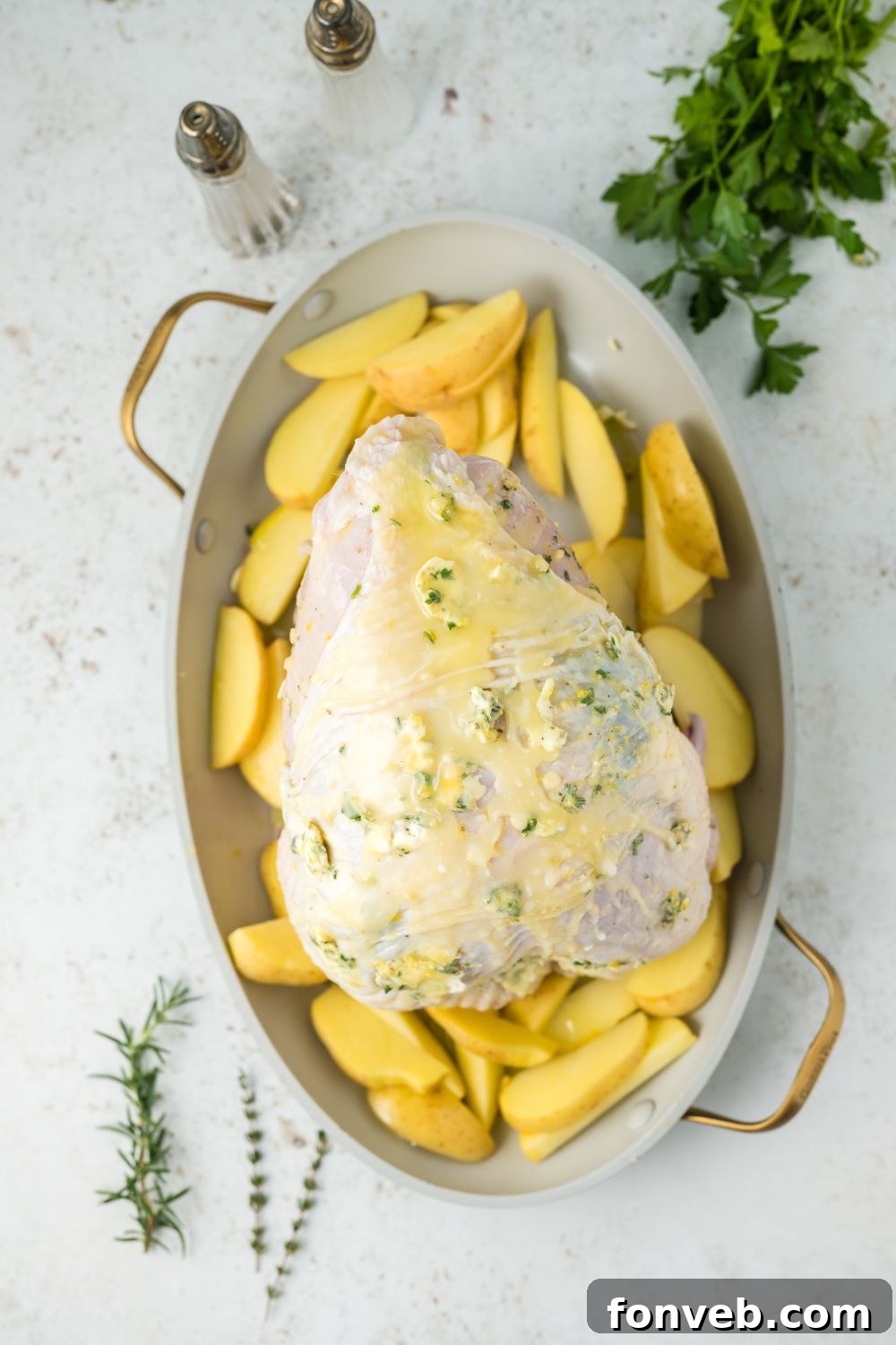 Raw turkey breast buttered and seasoned on a platter