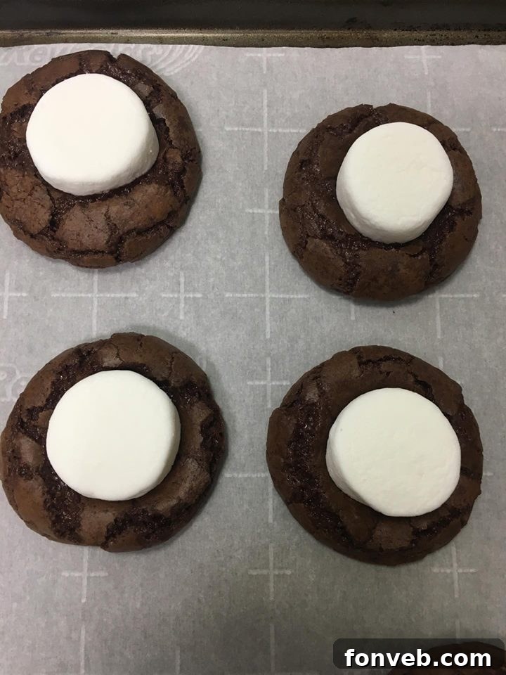 Step-by-step: Placing a halved marshmallow onto the center of a warm chocolate cookie