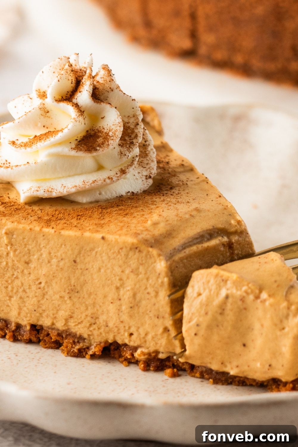 No Bake Gingerbread Cheesecake on plate with a fork cut on the top of it