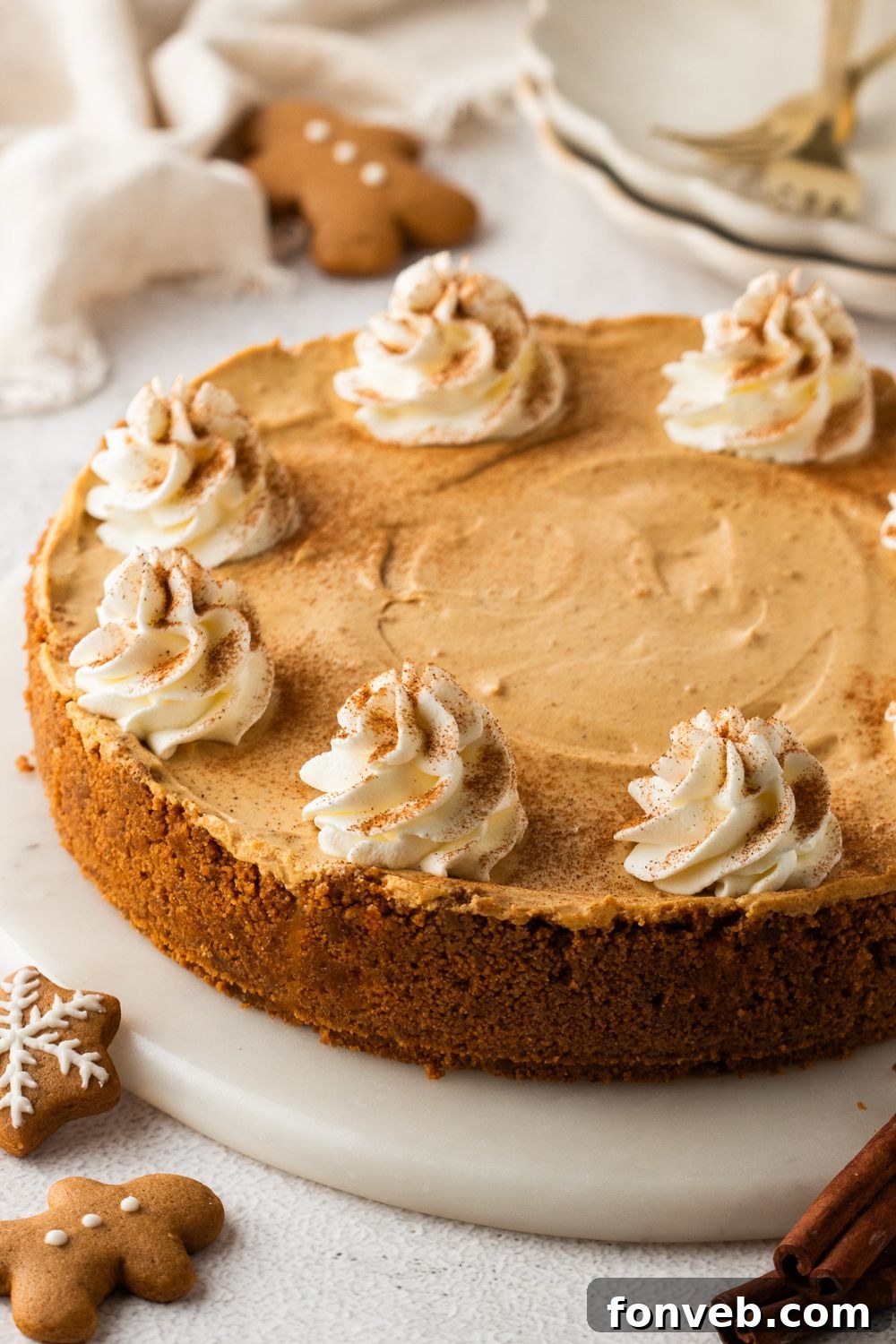 No Bake Gingerbread Cheesecake on a pie plate and gingerbread cookies around the table